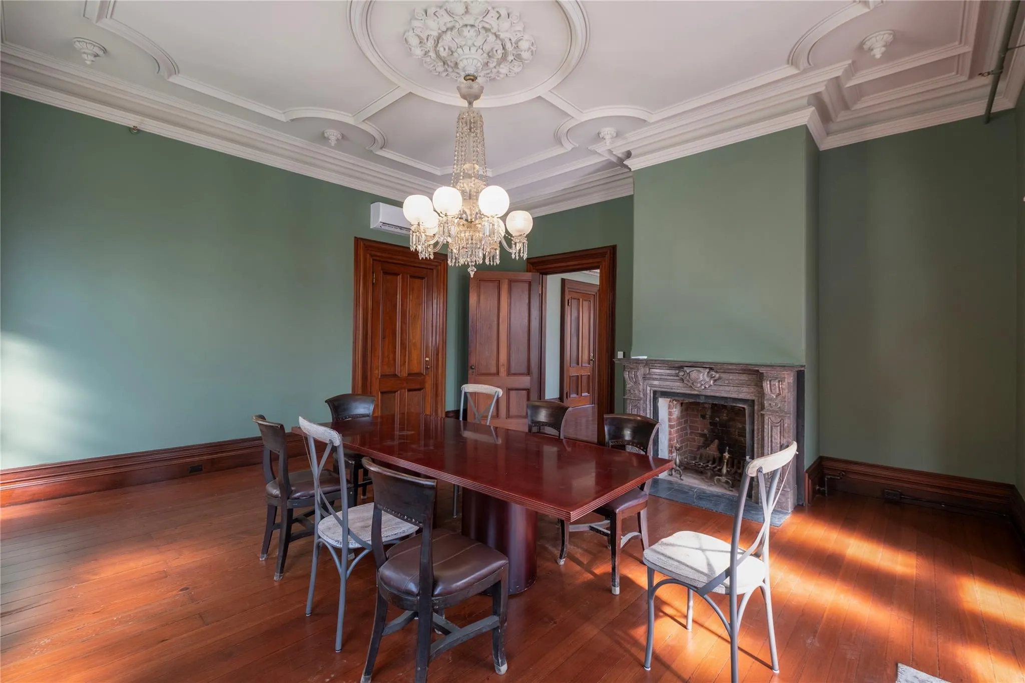 Dining space featuring a chandelier, a high end fireplace, and hardwood / wood-style floors Dining space featuring a chandelier, a high end fireplace, and hardwood / wood-style floors