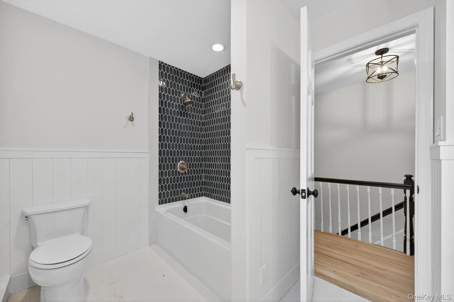 Bathroom featuring wainscoting, bathing tub / shower combination, and recessed lighting Bathroom featuring wainscoting, bathing tub / shower combination, and recessed lighting