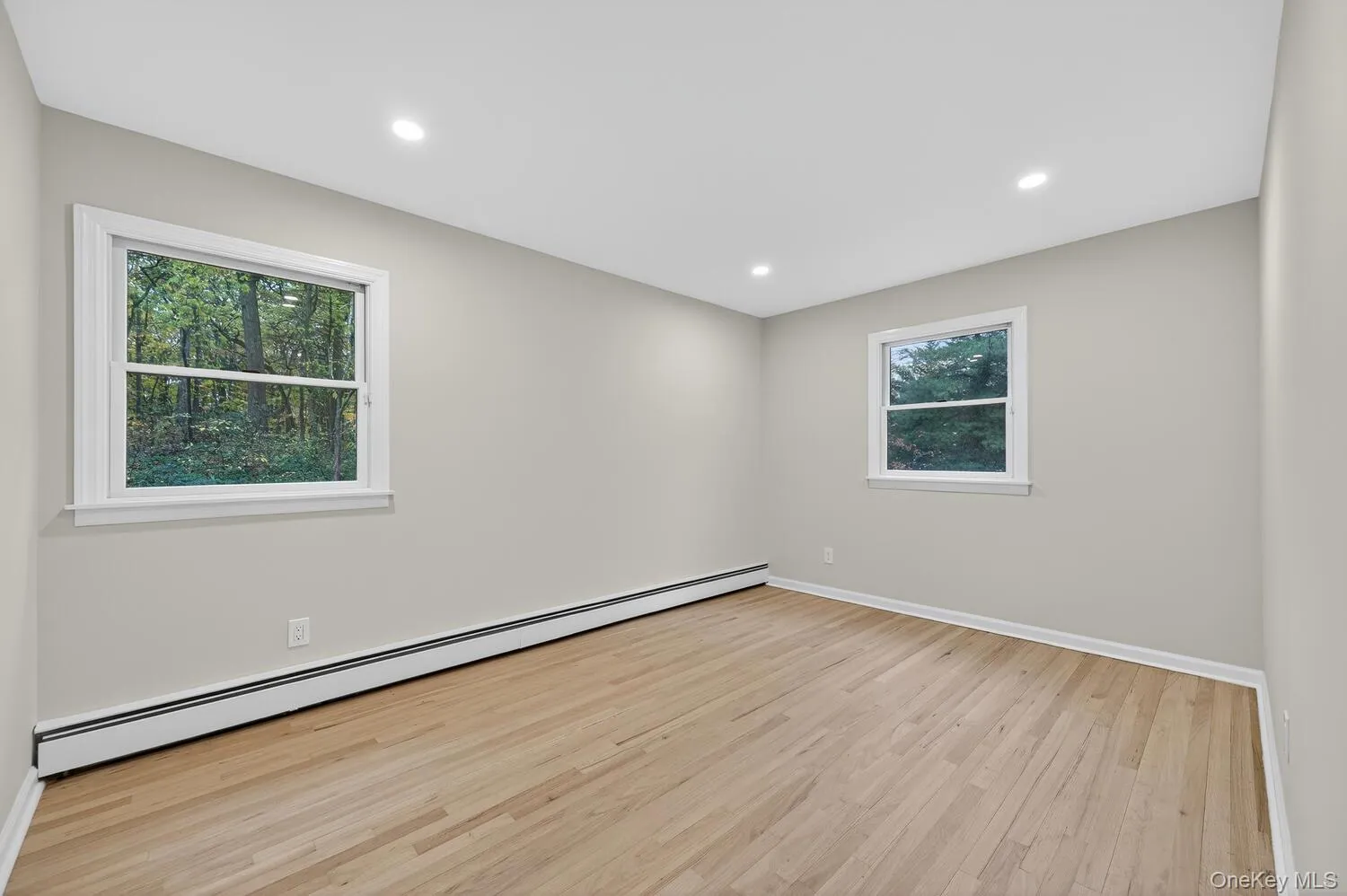 Unfurnished room with a baseboard radiator, light wood-style flooring, and recessed lighting Unfurnished room with a baseboard radiator, light wood-style flooring, and recessed lighting