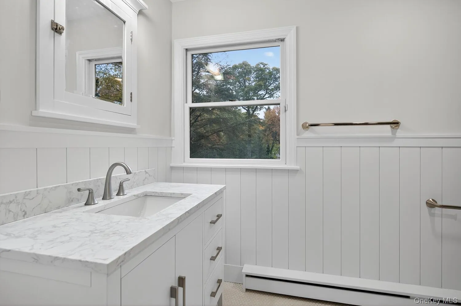 Guest bath Bathroom with a baseboard radiator, vanity, a wainscoted wall, and plenty of natural light Guest bath Bathroom with a baseboard radiator, vanity, a wainscoted wall, and plenty of natural light