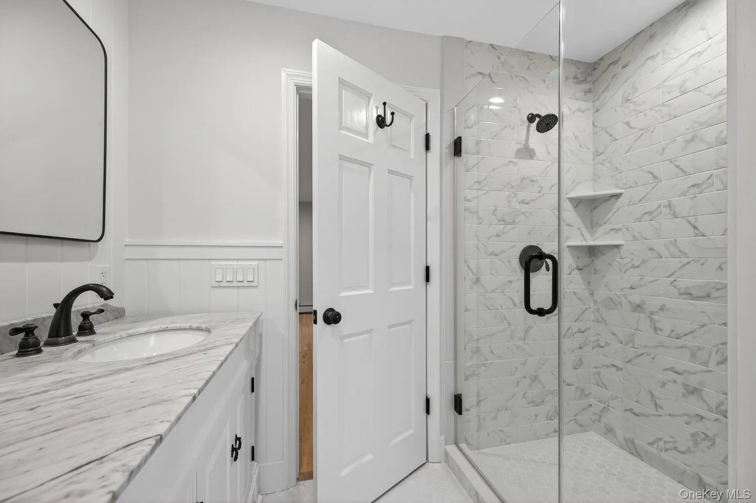 primary Bathroom with vanity, a shower stall, and wainscoting primary Bathroom with vanity, a shower stall, and wainscoting