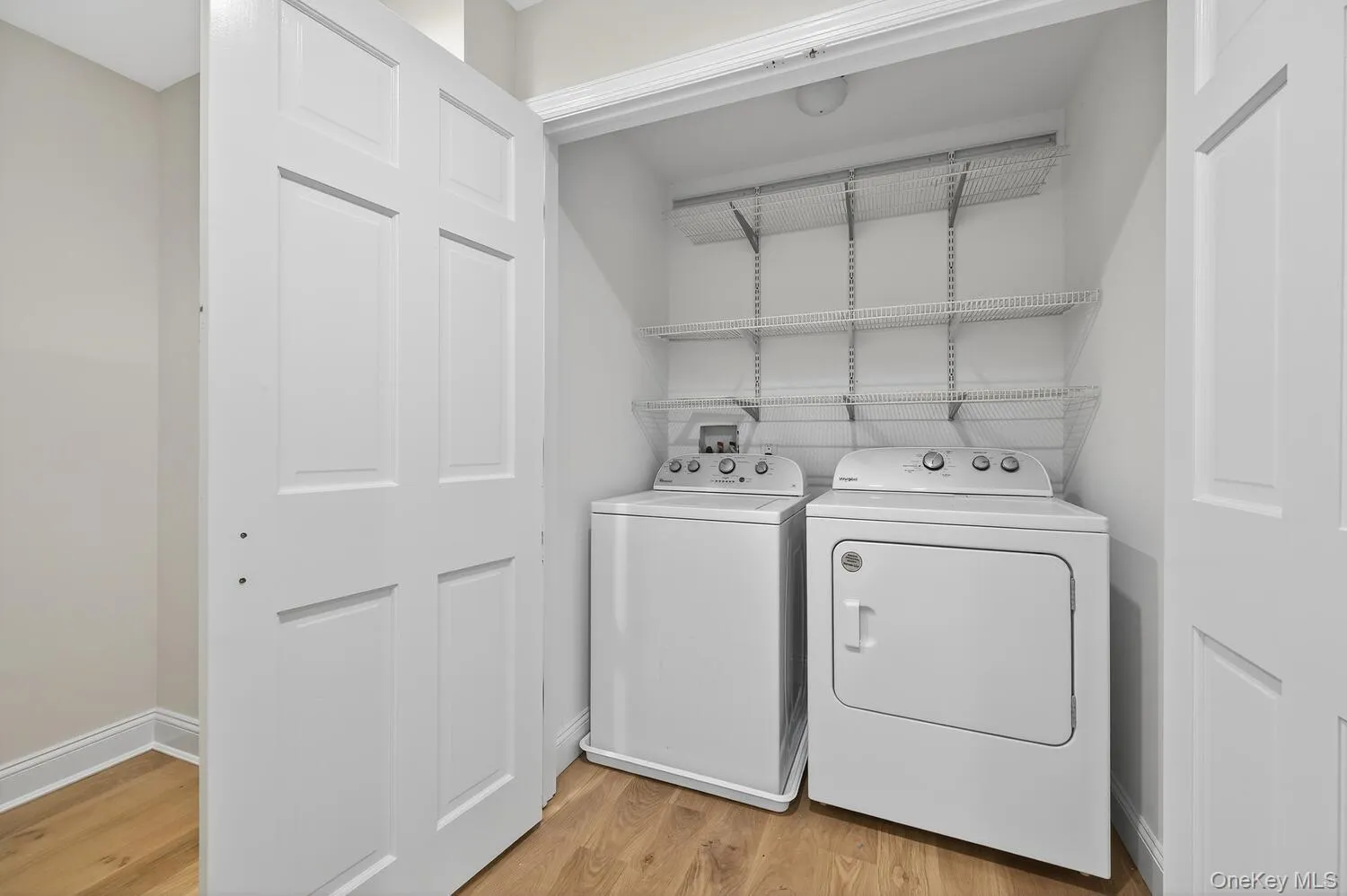 Laundry room featuring light wood-style floors and independent washer and dryer Laundry room featuring light wood-style floors and independent washer and dryer