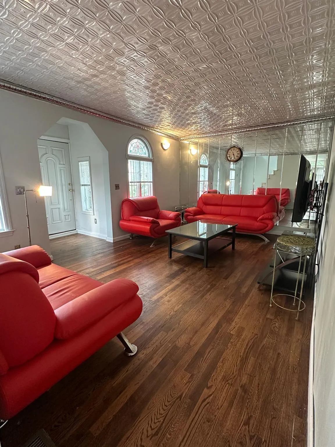 Living room featuring an ornate ceiling, arched walkways, wood finished floors, and ornamental molding Living room featuring an ornate ceiling, arched walkways, wood finished floors, and ornamental molding