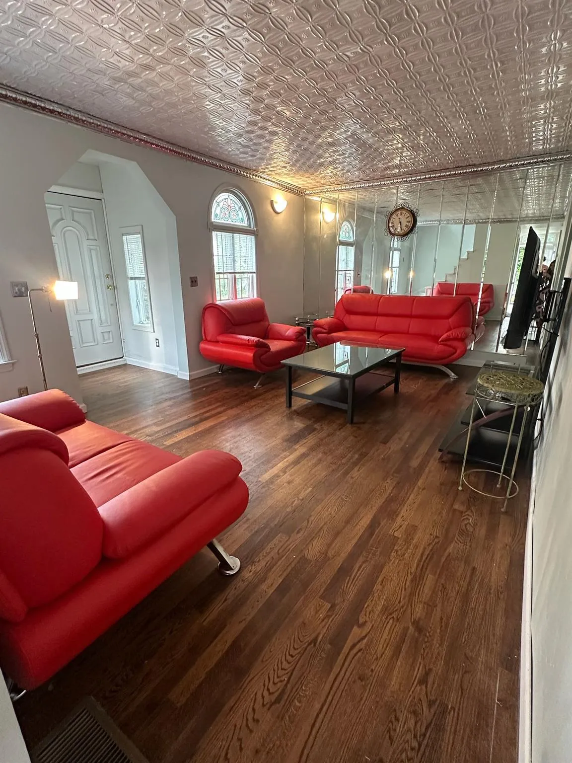 Living area featuring an ornate ceiling, arched walkways, wood finished floors, and crown molding Living area featuring an ornate ceiling, arched walkways, wood finished floors, and crown molding