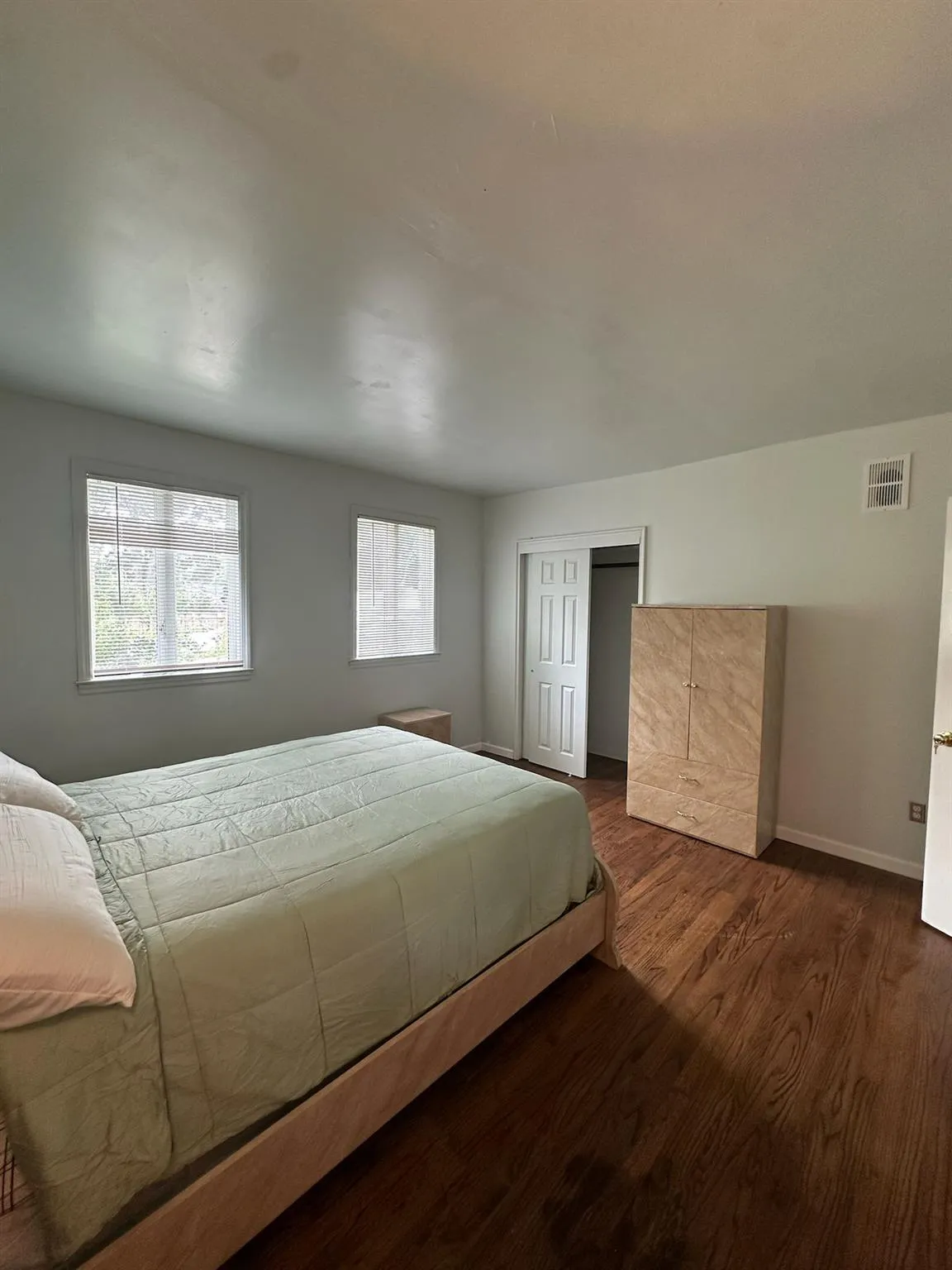 Bedroom with dark wood-type flooring and a closet Bedroom with dark wood-type flooring and a closet