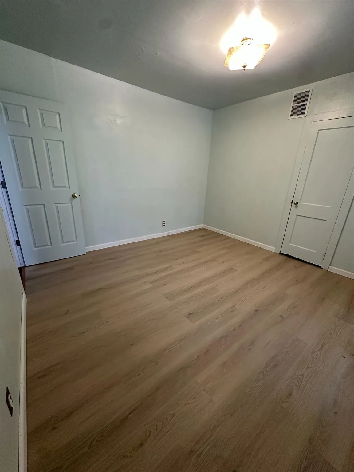 Empty room featuring wood finished floors and baseboards Empty room featuring wood finished floors and baseboards