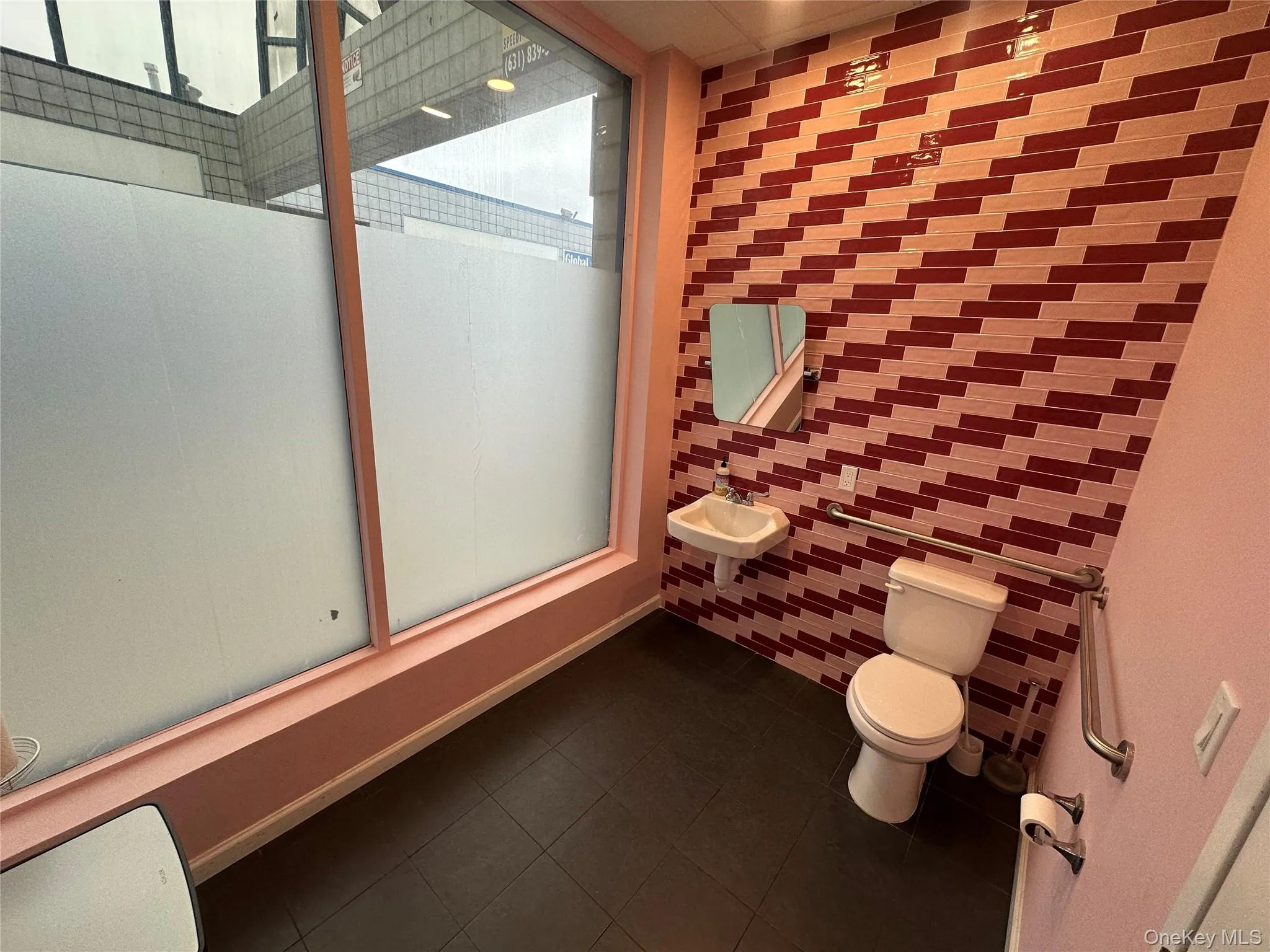 Bathroom featuring tile walls, a shower with shower door, and tile patterned floors Bathroom featuring tile walls, a shower with shower door, and tile patterned floors