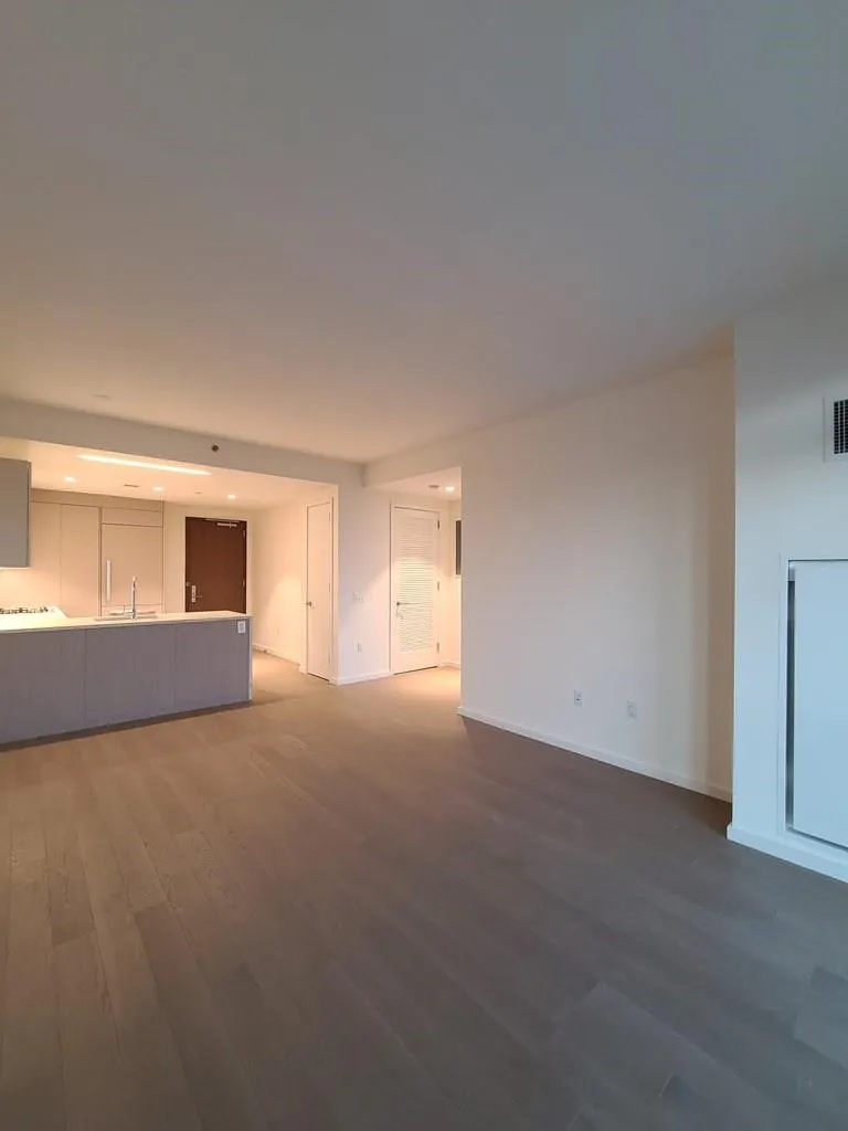 Unfurnished living room with dark wood finished floors and recessed lighting Unfurnished living room with dark wood finished floors and recessed lighting