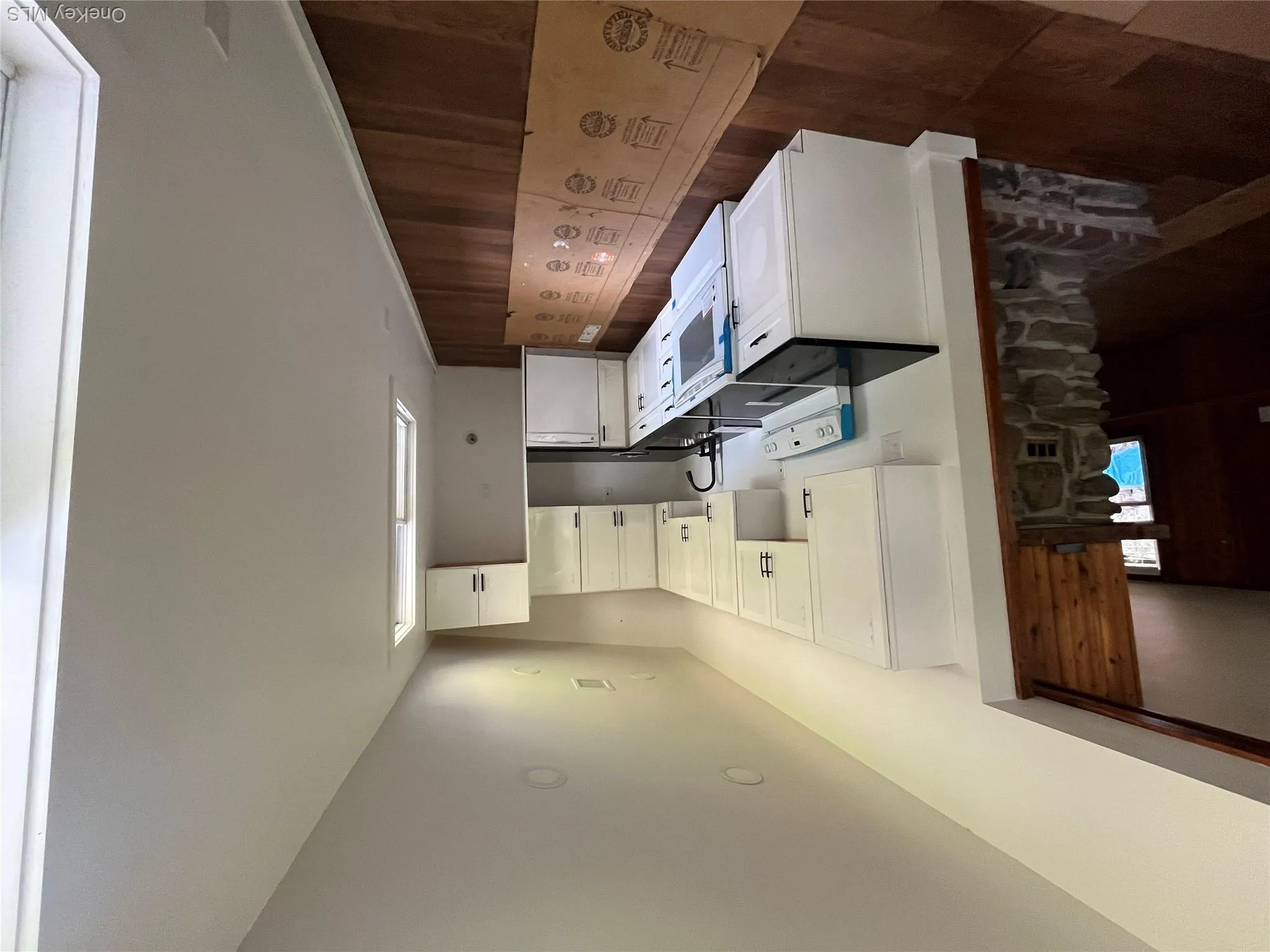Kitchen with range, dark countertops, dark wood-style floors, white cabinets, and vaulted ceiling Kitchen with range, dark countertops, dark wood-style floors, white cabinets, and vaulted ceiling