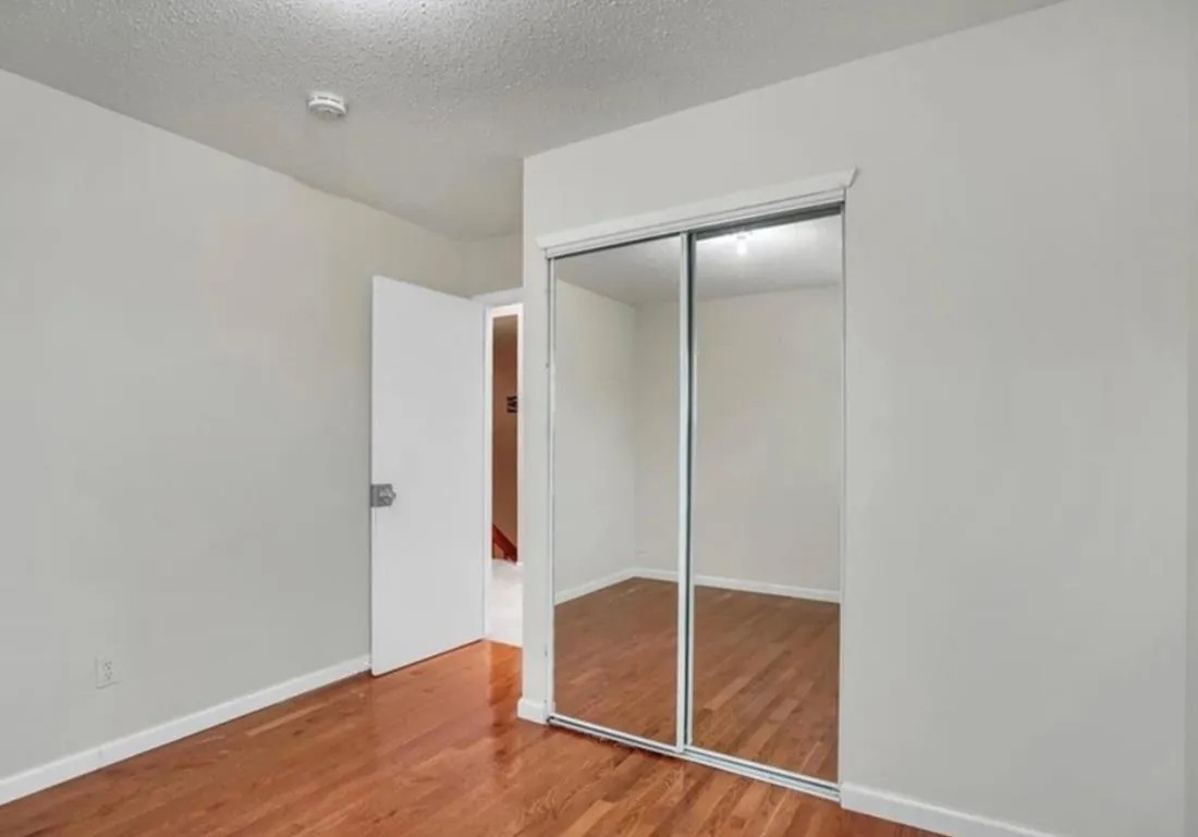 Unfurnished bedroom featuring a textured ceiling, wood finished floors, and a closet Unfurnished bedroom featuring a textured ceiling, wood finished floors, and a closet