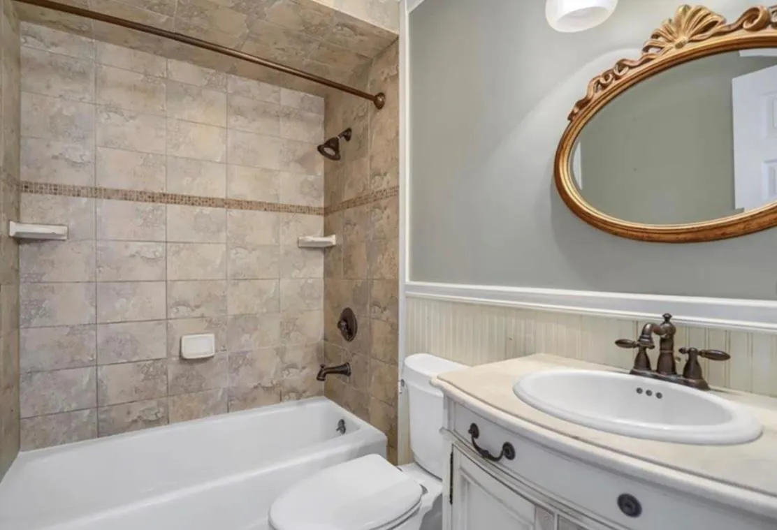 Bathroom featuring wainscoting, vanity, and shower / bathtub combination Bathroom featuring wainscoting, vanity, and shower / bathtub combination