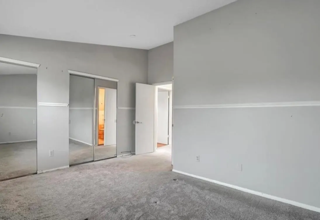 Unfurnished bedroom with two closets, carpet floors, and lofted ceiling Unfurnished bedroom with two closets, carpet floors, and lofted ceiling