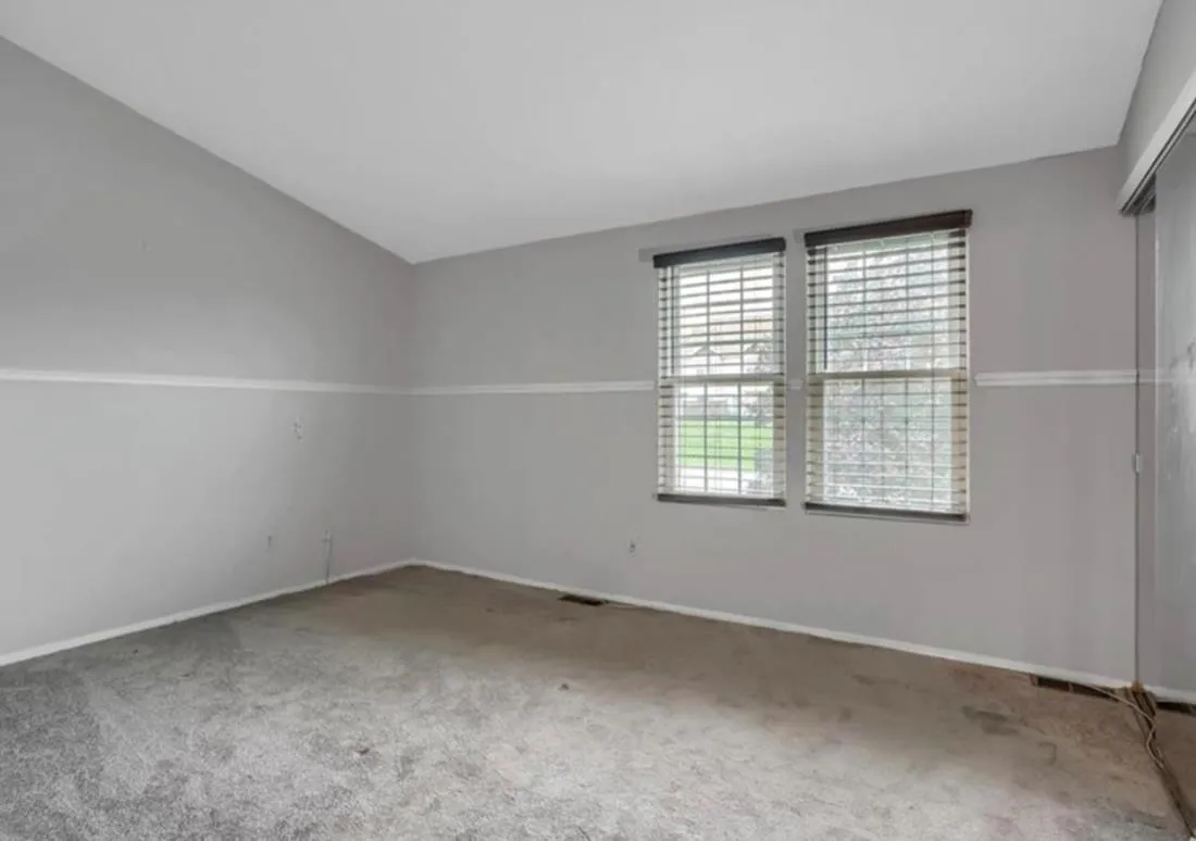Carpeted spare room with vaulted ceiling and baseboards Carpeted spare room with vaulted ceiling and baseboards