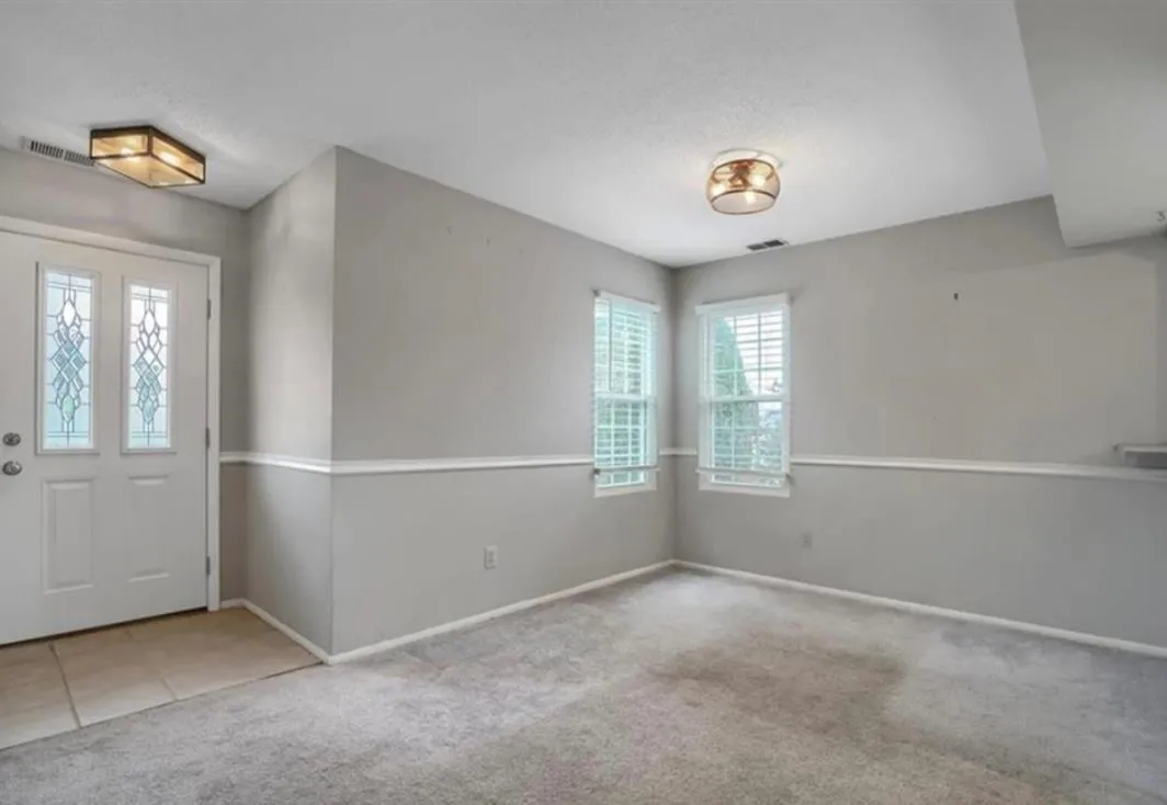 Carpeted foyer with plenty of natural light, a textured ceiling, and tile patterned floors Carpeted foyer with plenty of natural light, a textured ceiling, and tile patterned floors