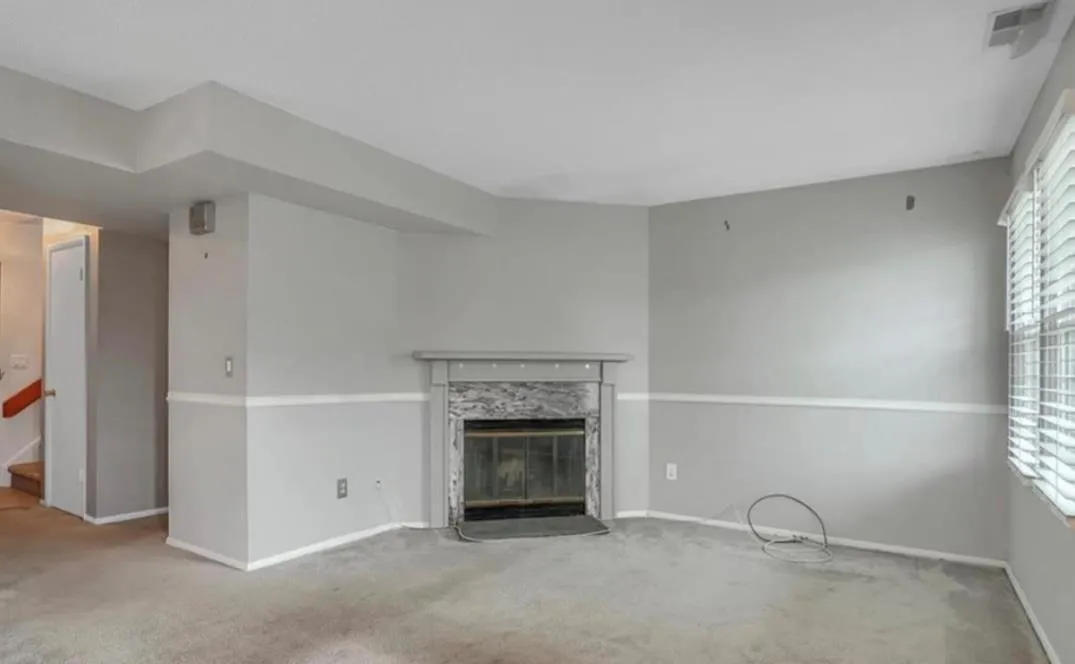 Unfurnished living room featuring carpet and a glass covered fireplace Unfurnished living room featuring carpet and a glass covered fireplace