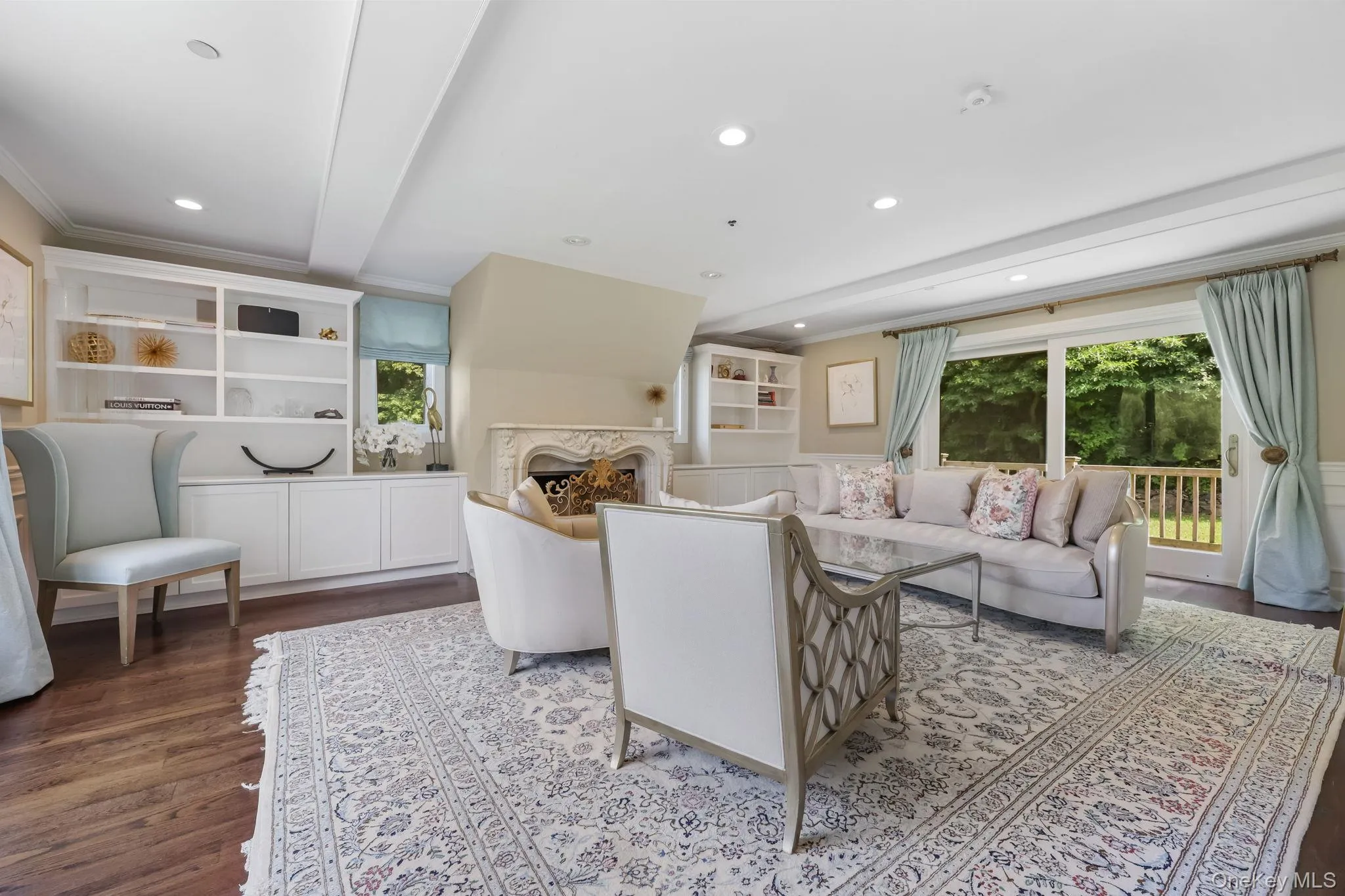 Living room featuring dark wood-style floors, a fireplace, recessed lighting, beamed ceiling, and crown molding Living room featuring dark wood-style floors, a fireplace, recessed lighting, beamed ceiling, and crown molding