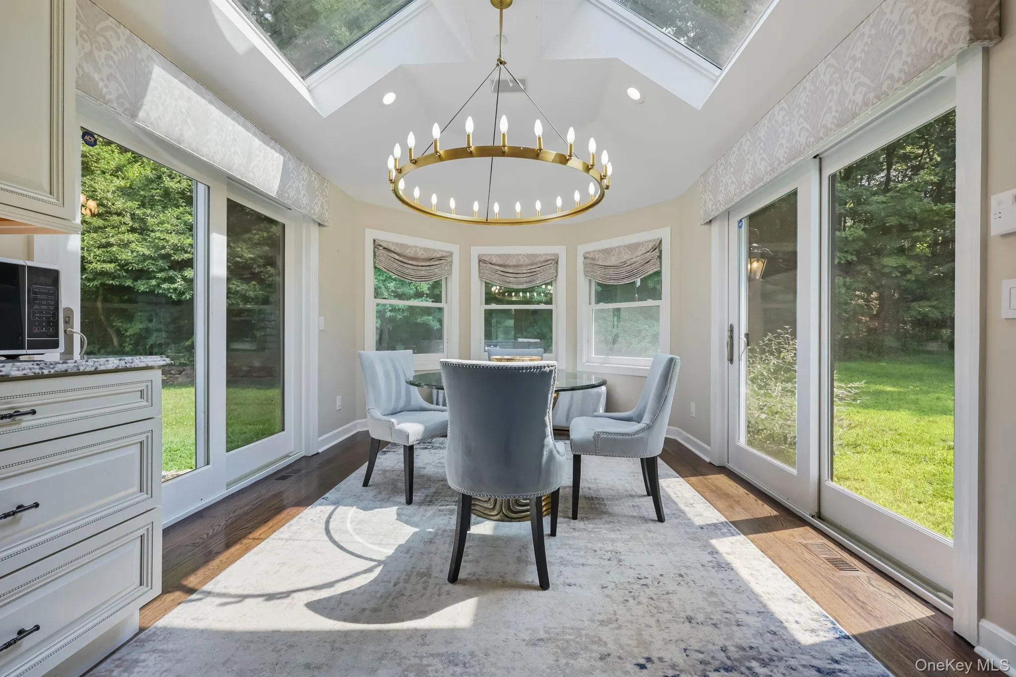 Sunroom featuring a chandelier, a skylight, wood finished floors, and recessed lighting Sunroom featuring a chandelier, a skylight, wood finished floors, and recessed lighting