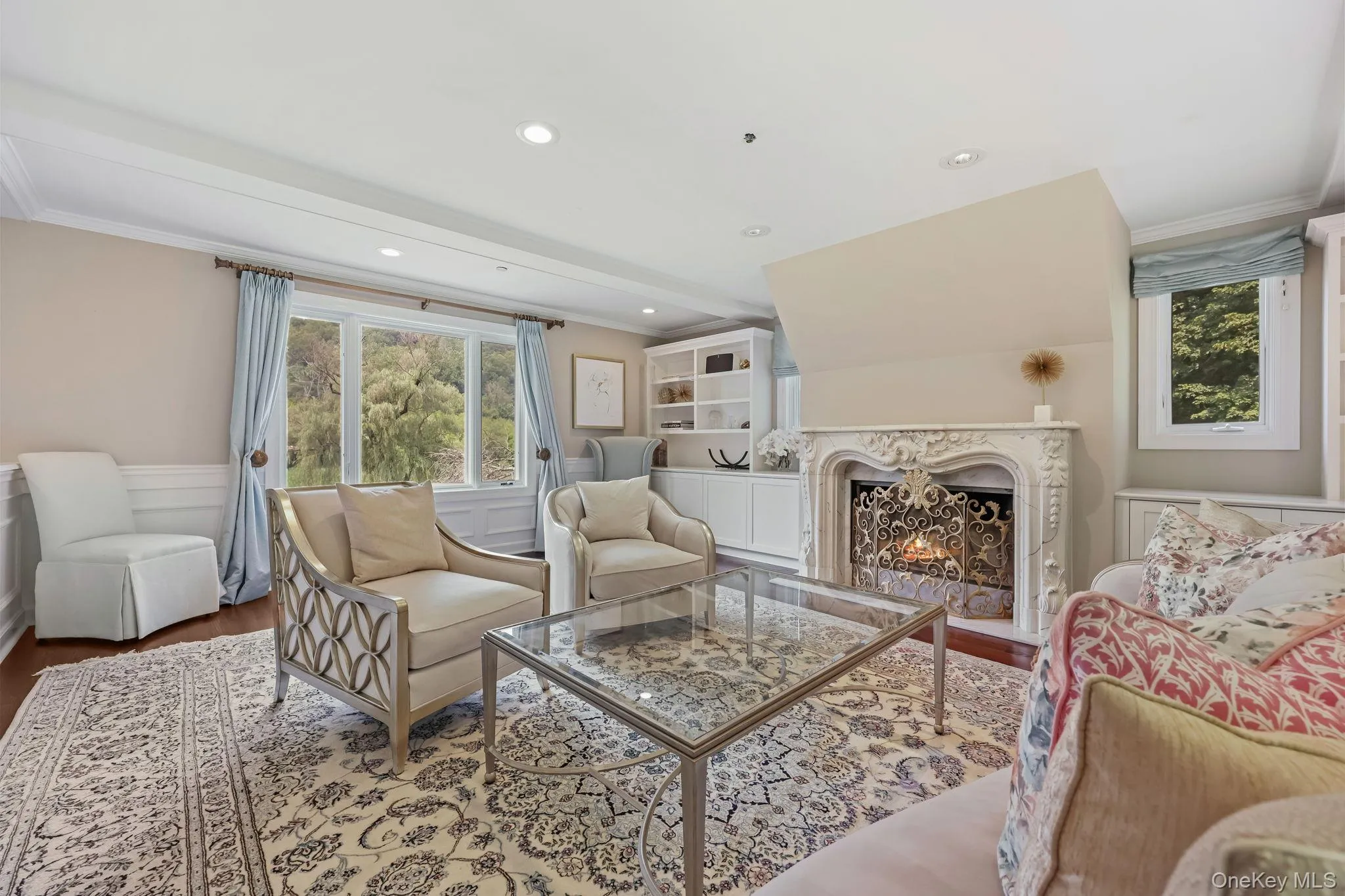 Living room with a premium fireplace, wood finished floors, crown molding, and recessed lighting Living room with a premium fireplace, wood finished floors, crown molding, and recessed lighting