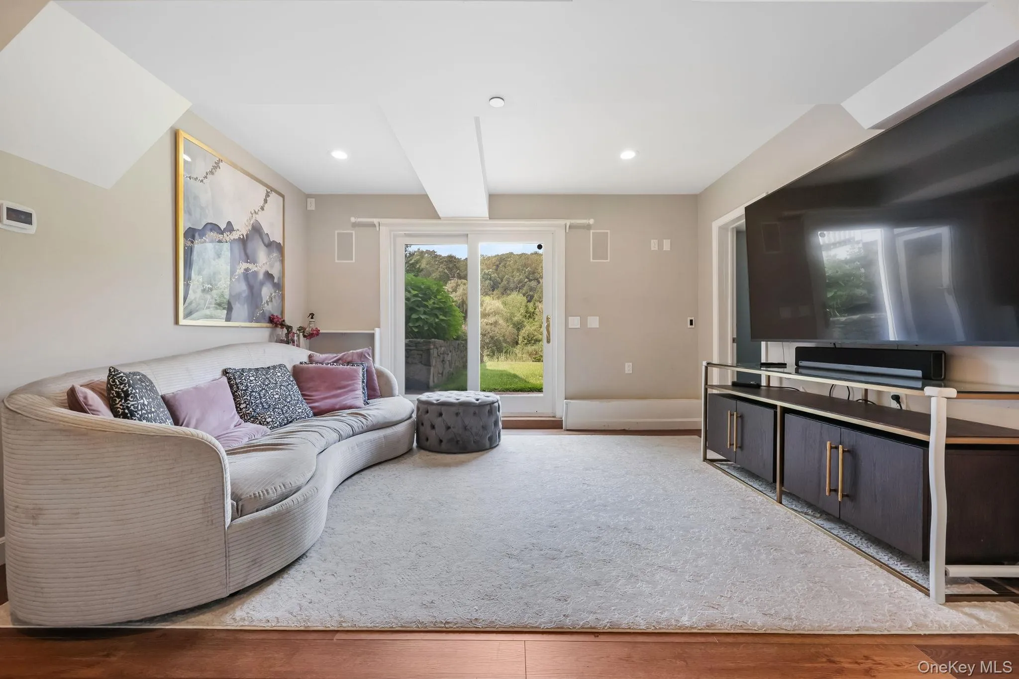 Living room featuring light wood-style flooring, beamed ceiling, and recessed lighting Living room featuring light wood-style flooring, beamed ceiling, and recessed lighting