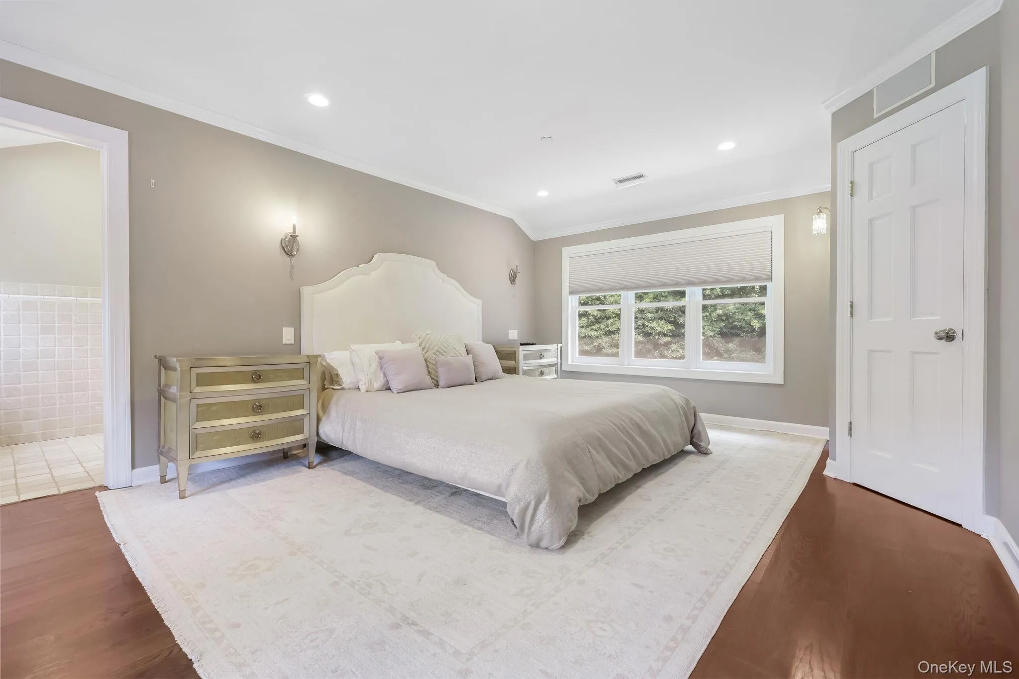 Bedroom with crown molding, recessed lighting, dark wood-style floors, and ensuite bathroom Bedroom with crown molding, recessed lighting, dark wood-style floors, and ensuite bathroom