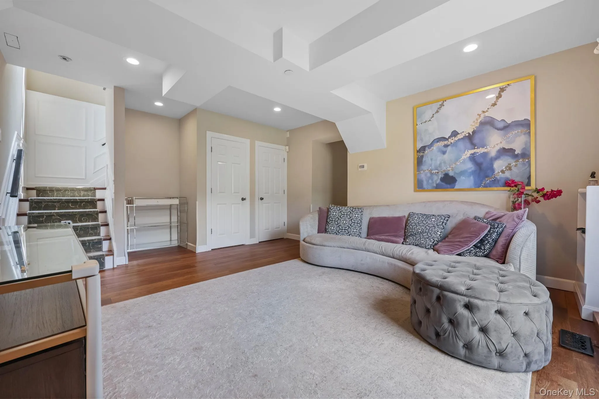 Living room featuring dark wood-style floors, recessed lighting, and stairway Living room featuring dark wood-style floors, recessed lighting, and stairway