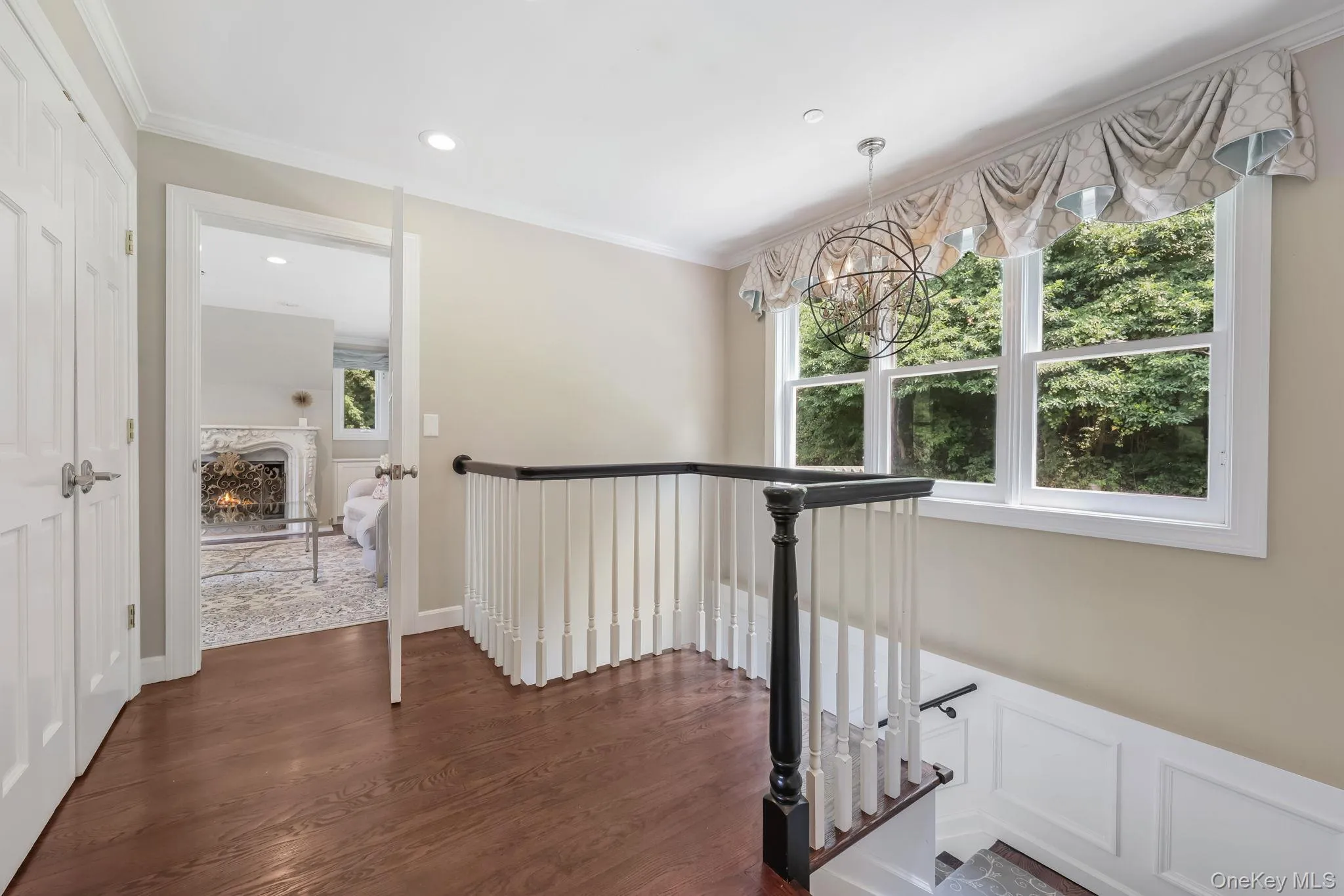 Hallway with crown molding, dark wood-style floors, an upstairs landing, a chandelier, and recessed lighting Hallway with crown molding, dark wood-style floors, an upstairs landing, a chandelier, and recessed lighting