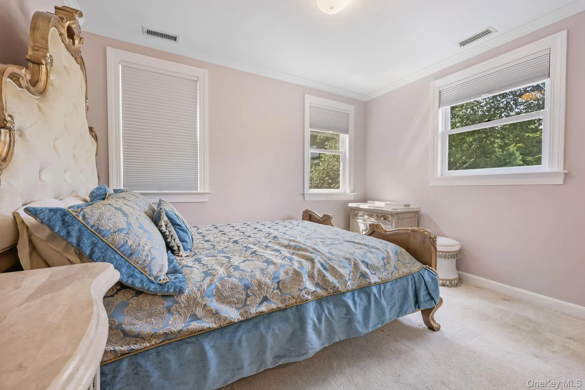 Carpeted bedroom with crown molding and baseboards Carpeted bedroom with crown molding and baseboards