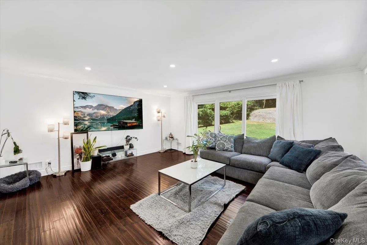 Living area with wood finished floors, ornamental molding, and recessed lighting Living area with wood finished floors, ornamental molding, and recessed lighting