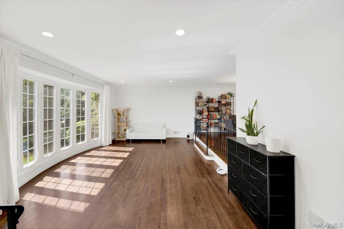 Corridor with dark wood-style floors, crown molding, and recessed lighting Corridor with dark wood-style floors, crown molding, and recessed lighting