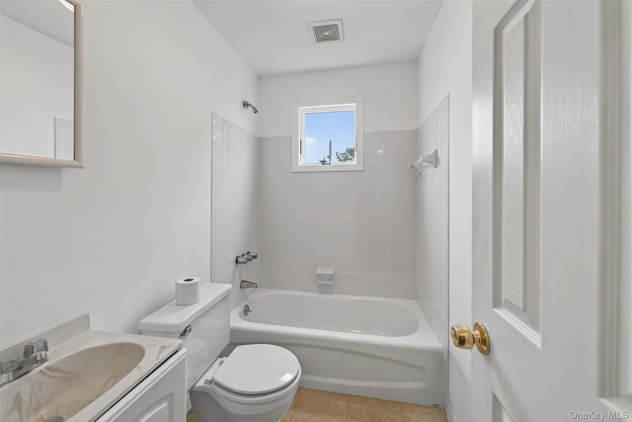Bathroom featuring washtub / shower combination, vanity, and tile patterned flooring Bathroom featuring washtub / shower combination, vanity, and tile patterned flooring