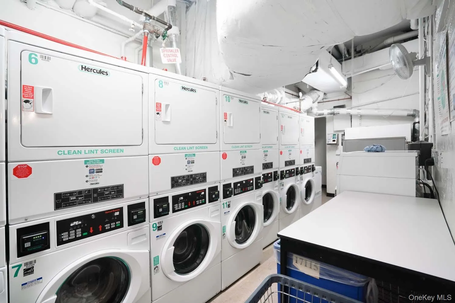 Community laundry room with stacked washer and clothes dryer and washing machine and dryer Community laundry room with stacked washer and clothes dryer and washing machine and dryer