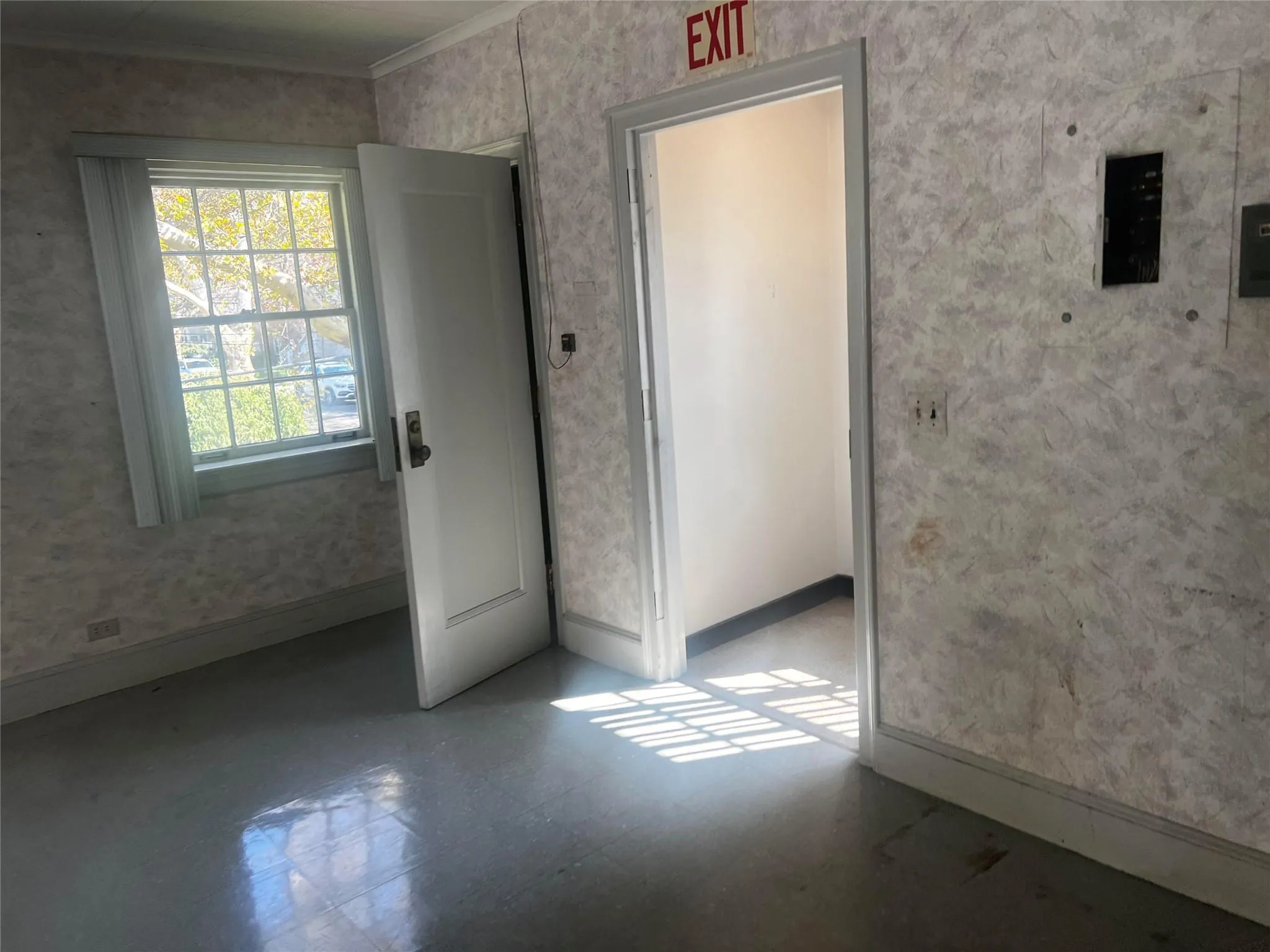 Unfurnished room featuring wallpapered walls and tile patterned floors Unfurnished room featuring wallpapered walls and tile patterned floors