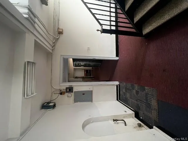 Hallway featuring electric panel, stairs, and dark colored carpet Hallway featuring electric panel, stairs, and dark colored carpet