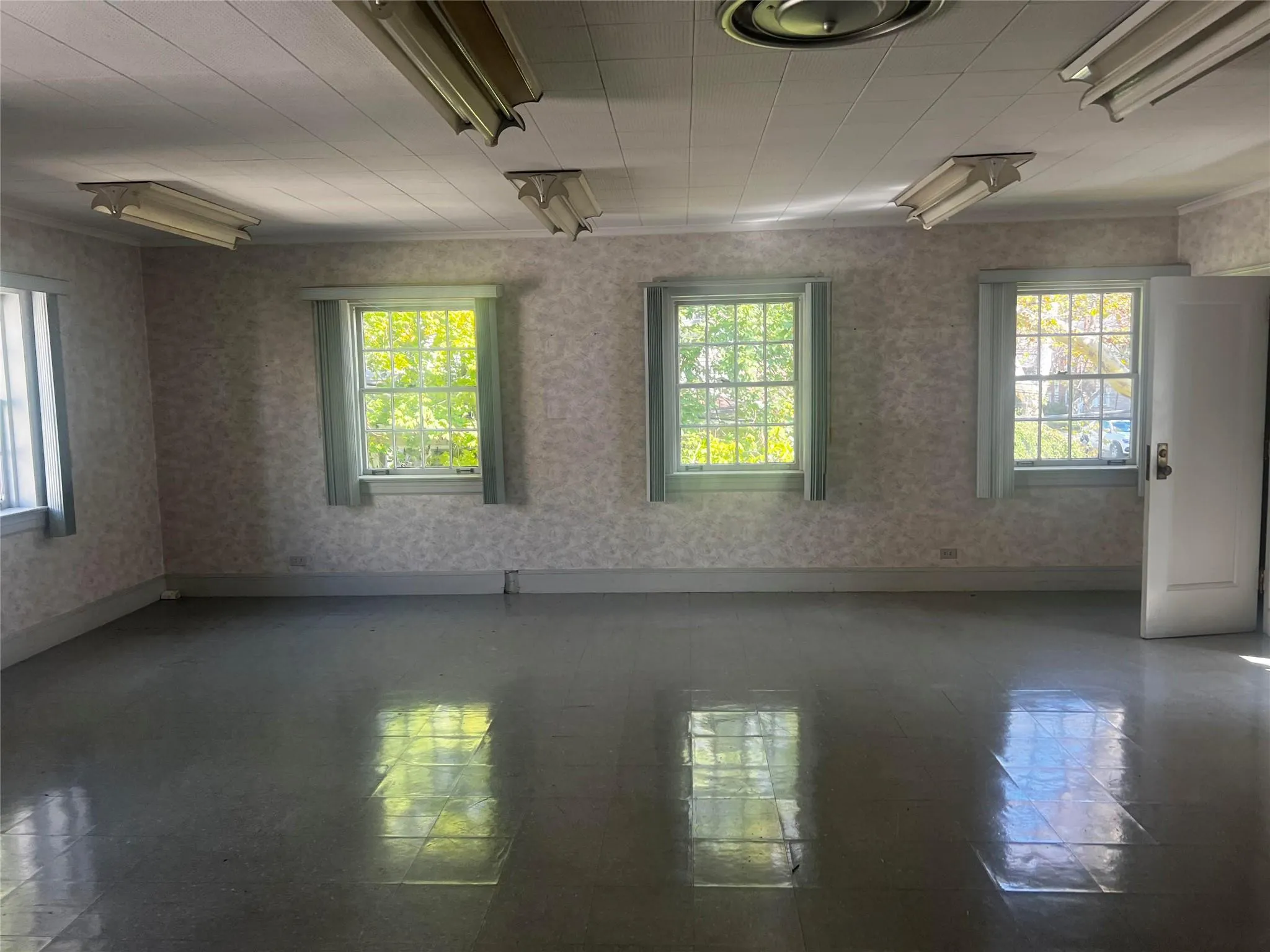 Spare room featuring healthy amount of natural light and wallpapered walls Spare room featuring healthy amount of natural light and wallpapered walls