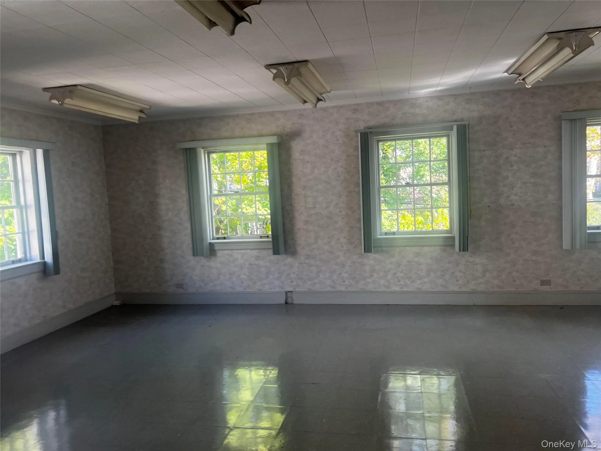 Spare room featuring plenty of natural light and tile patterned floors Spare room featuring plenty of natural light and tile patterned floors