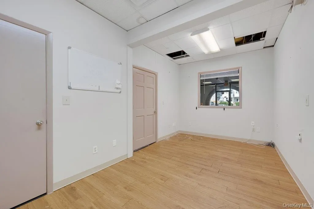 Spare room featuring a paneled ceiling and light wood-style floors Spare room featuring a paneled ceiling and light wood-style floors