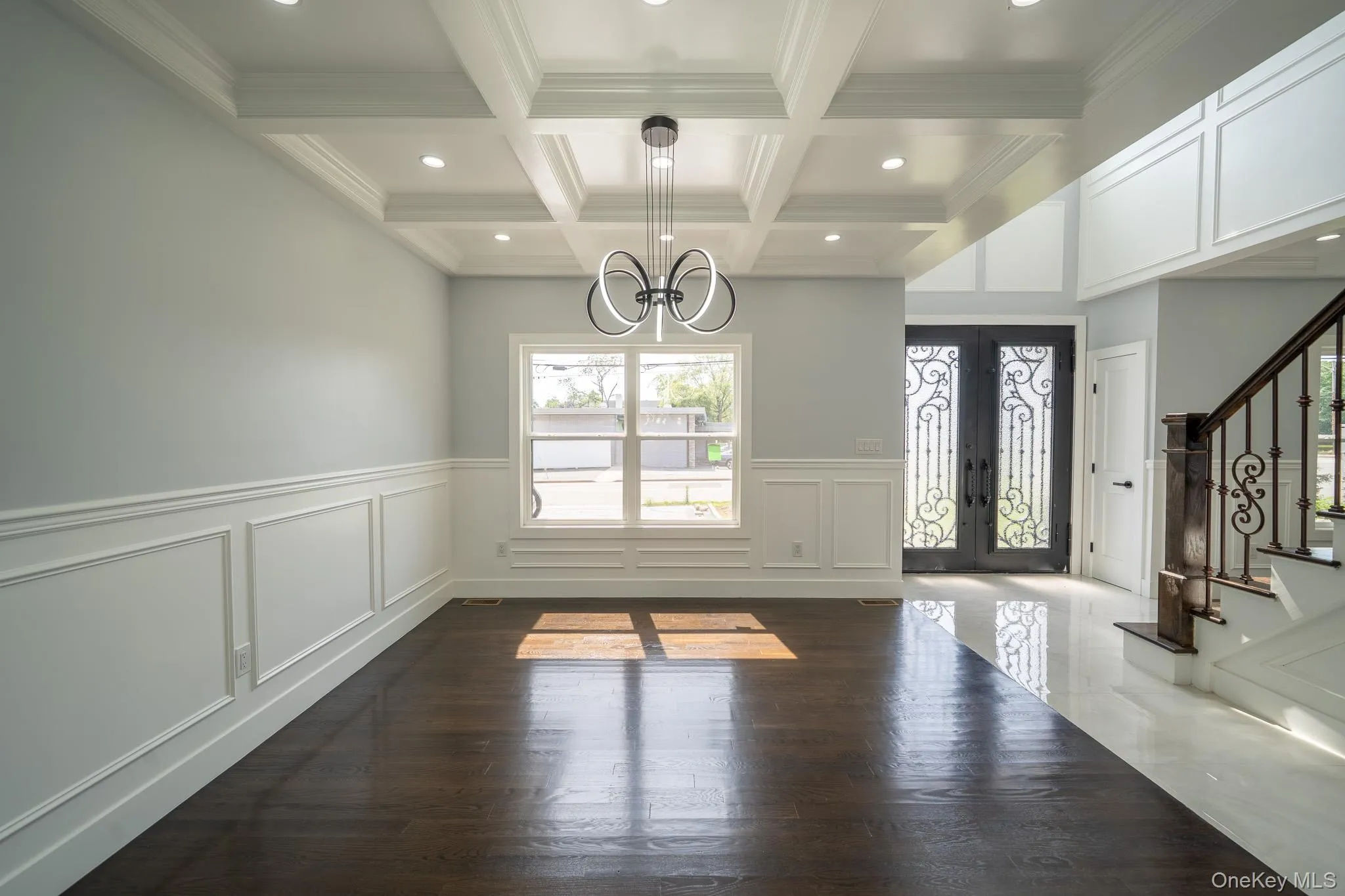 Unfurnished dining area with french doors, a chandelier, dark wood-style flooring, stairway, and beamed ceiling Unfurnished dining area with french doors, a chandelier, dark wood-style flooring, stairway, and beamed ceiling