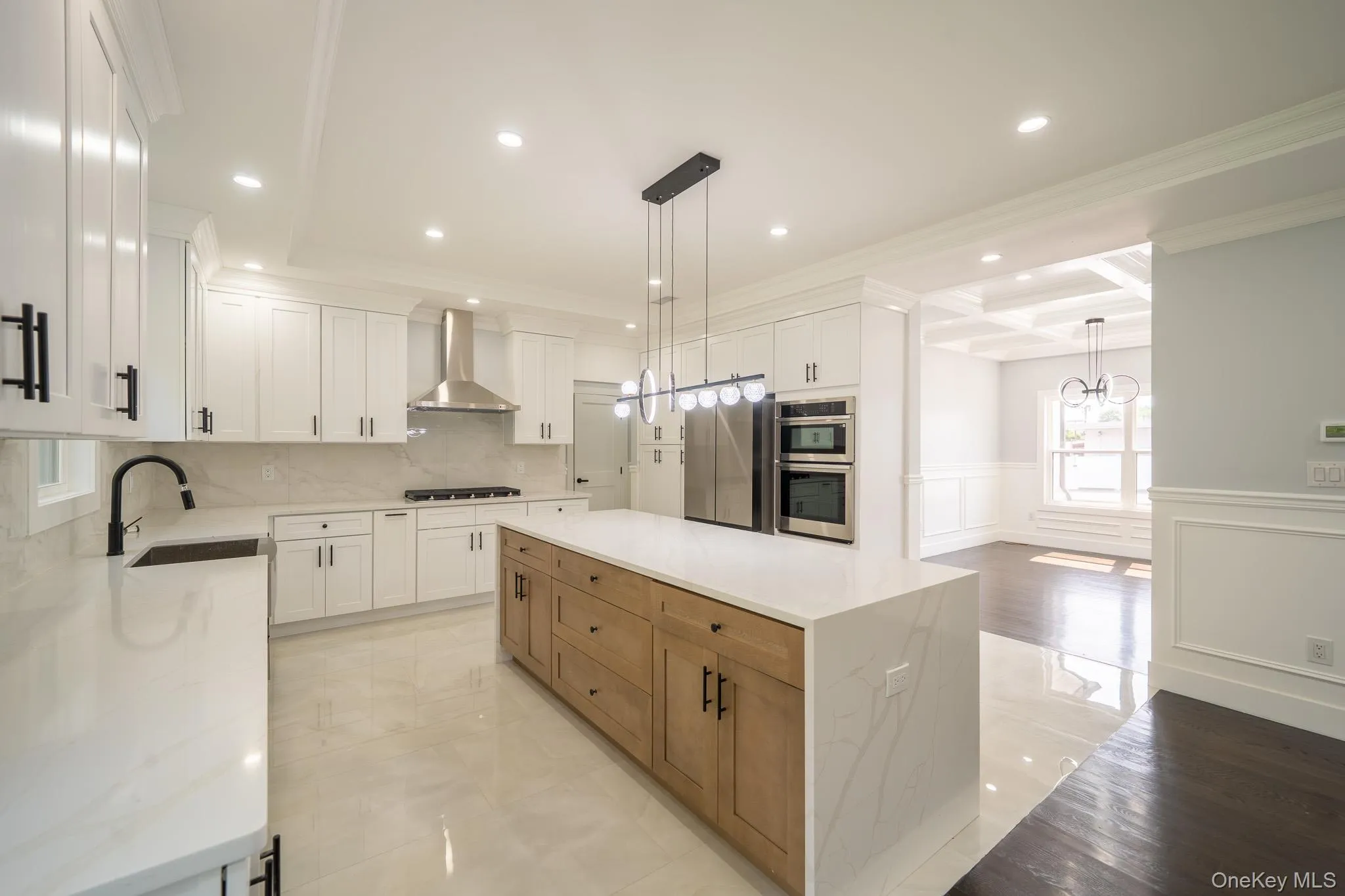 Kitchen with a decorative wall, a wainscoted wall, coffered ceiling, a center island, and crown molding Kitchen with a decorative wall, a wainscoted wall, coffered ceiling, a center island, and crown molding