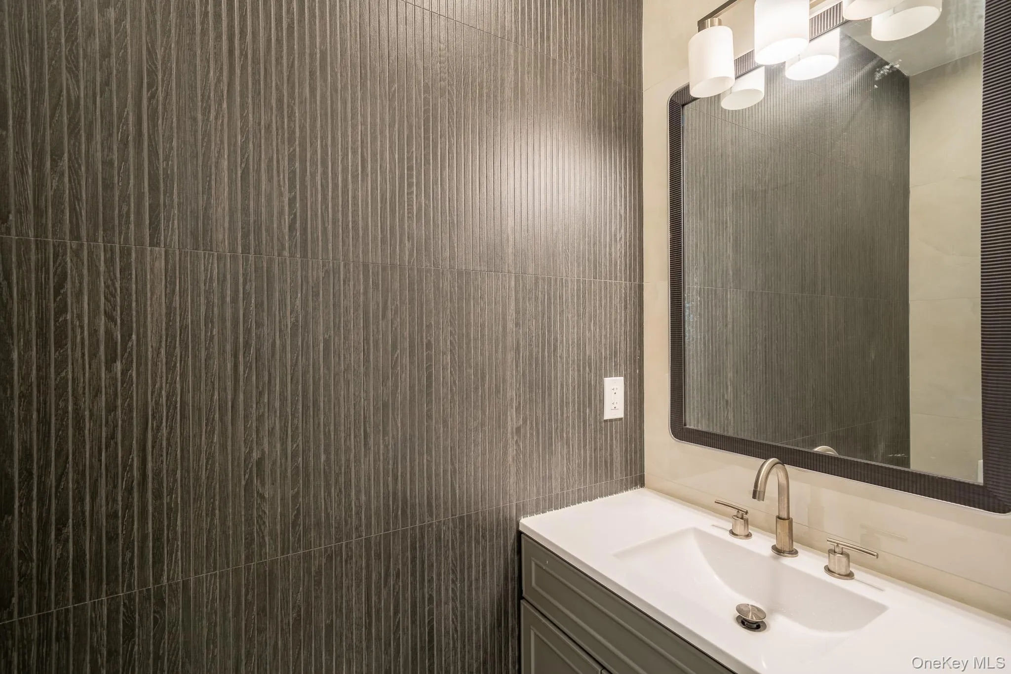Bathroom featuring vanity and tile walls Bathroom featuring vanity and tile walls