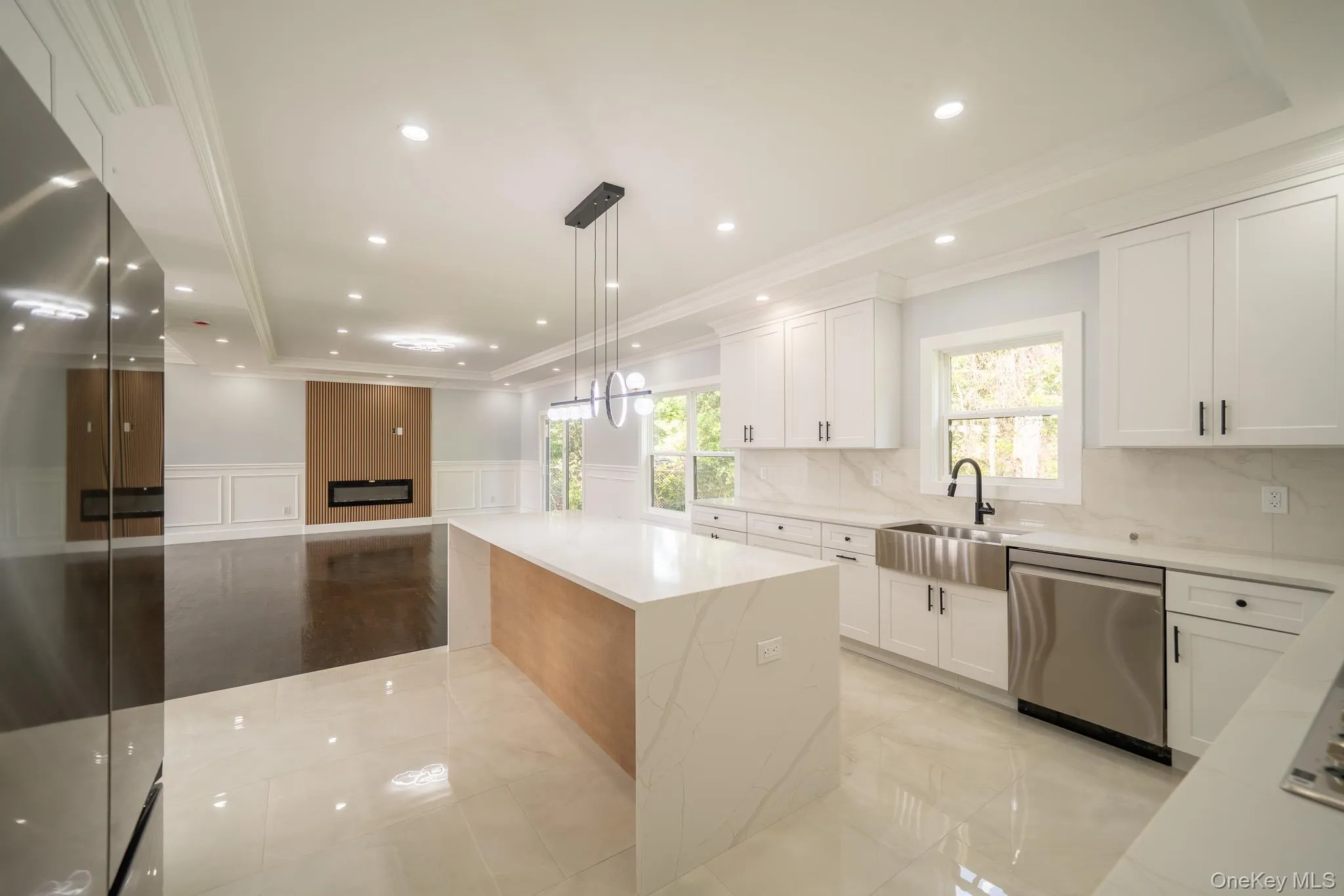 Kitchen featuring a decorative wall, a wainscoted wall, stainless steel appliances, crown molding, and light stone counters Kitchen featuring a decorative wall, a wainscoted wall, stainless steel appliances, crown molding, and light stone counters