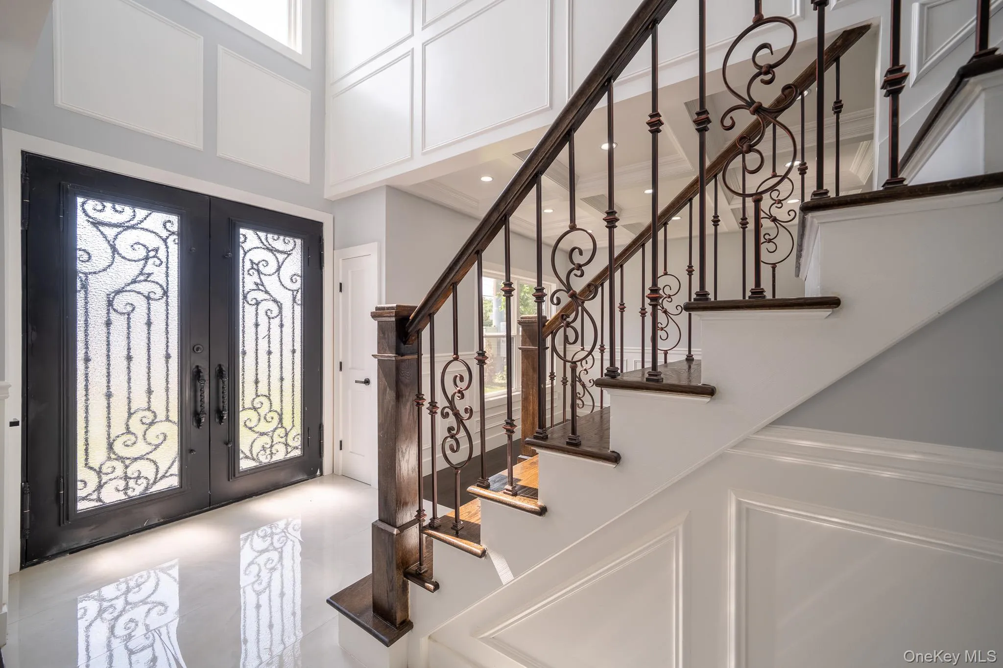 Foyer entrance with healthy amount of natural light, french doors, and a decorative wall Foyer entrance with healthy amount of natural light, french doors, and a decorative wall