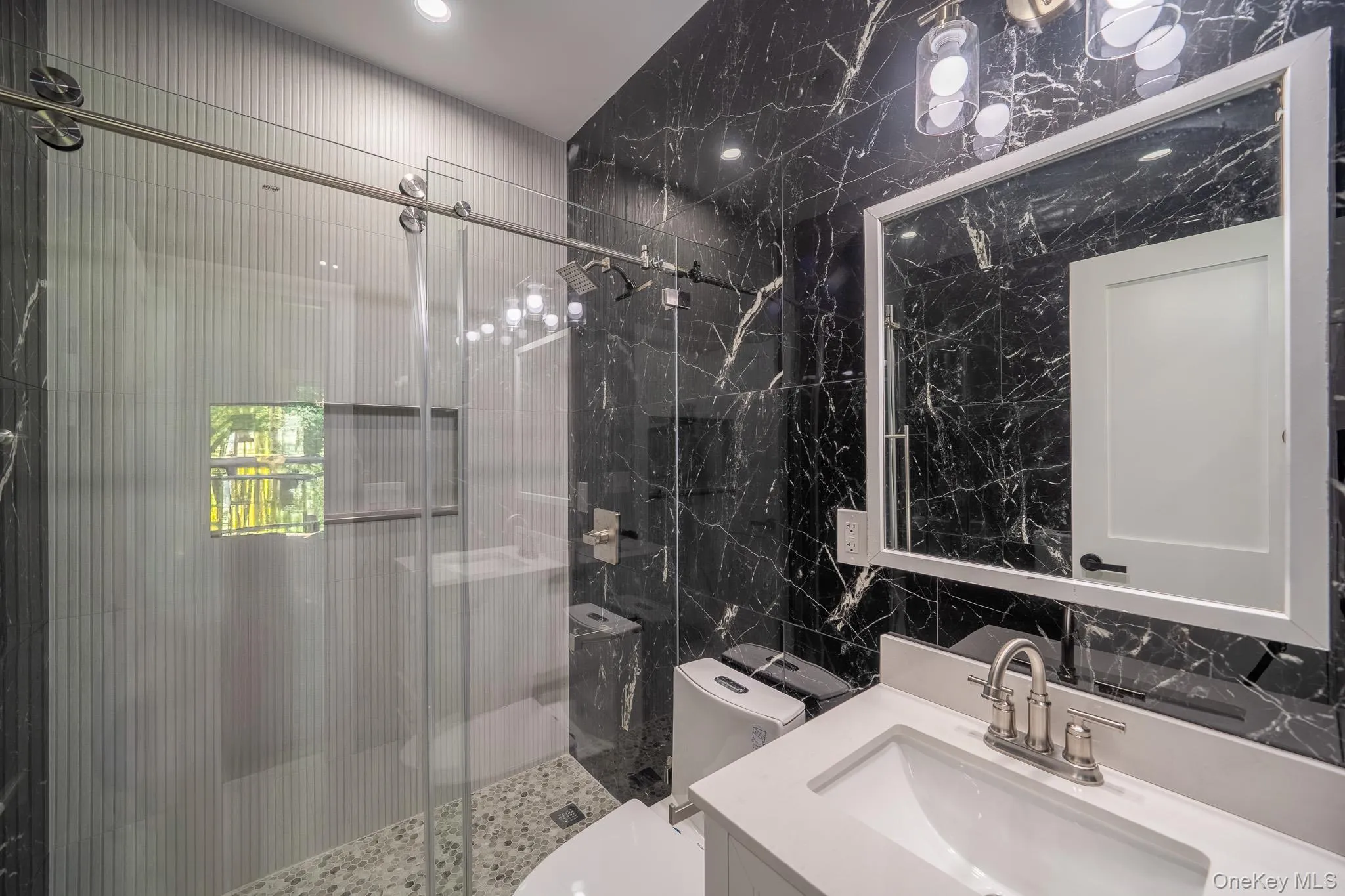 Bathroom featuring tile walls, a stall shower, and vanity Bathroom featuring tile walls, a stall shower, and vanity