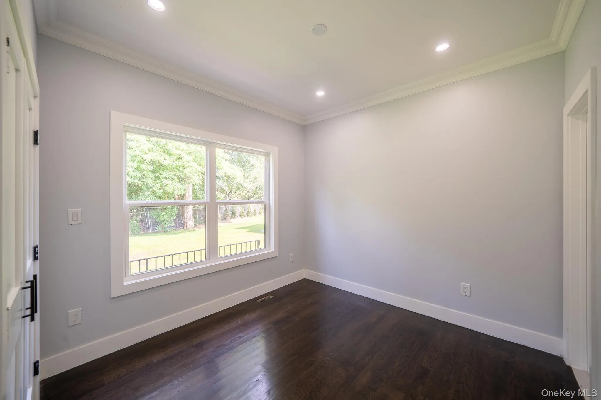Unfurnished room with dark wood-style floors, ornamental molding, and recessed lighting Unfurnished room with dark wood-style floors, ornamental molding, and recessed lighting