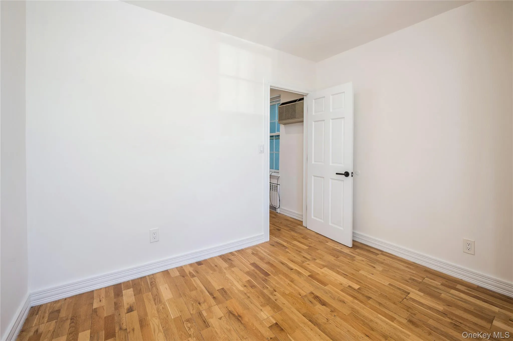 Spare room with wood finished floors and radiator Spare room with wood finished floors and radiator