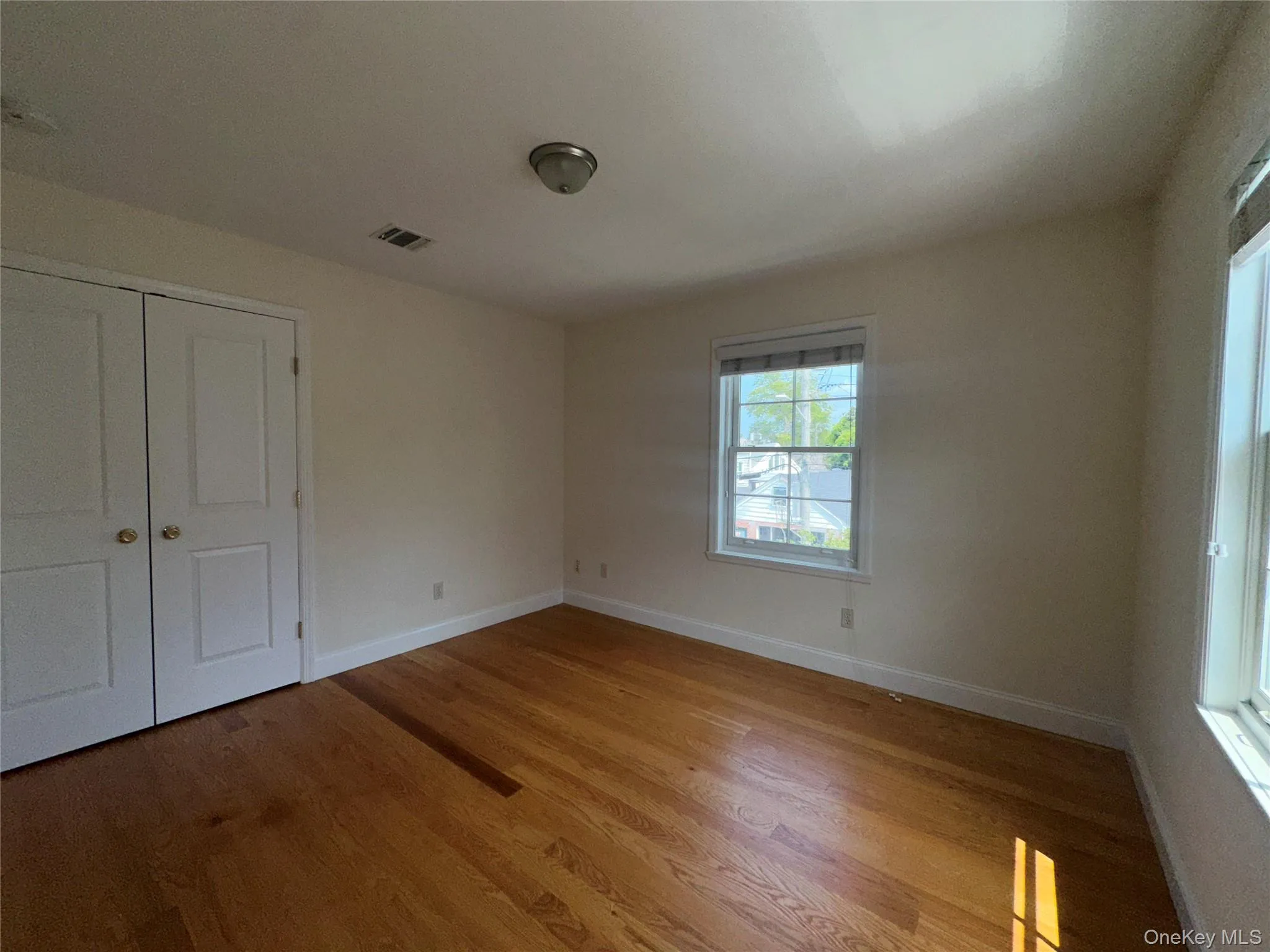 Unfurnished bedroom with wood finished floors and a closet Unfurnished bedroom with wood finished floors and a closet