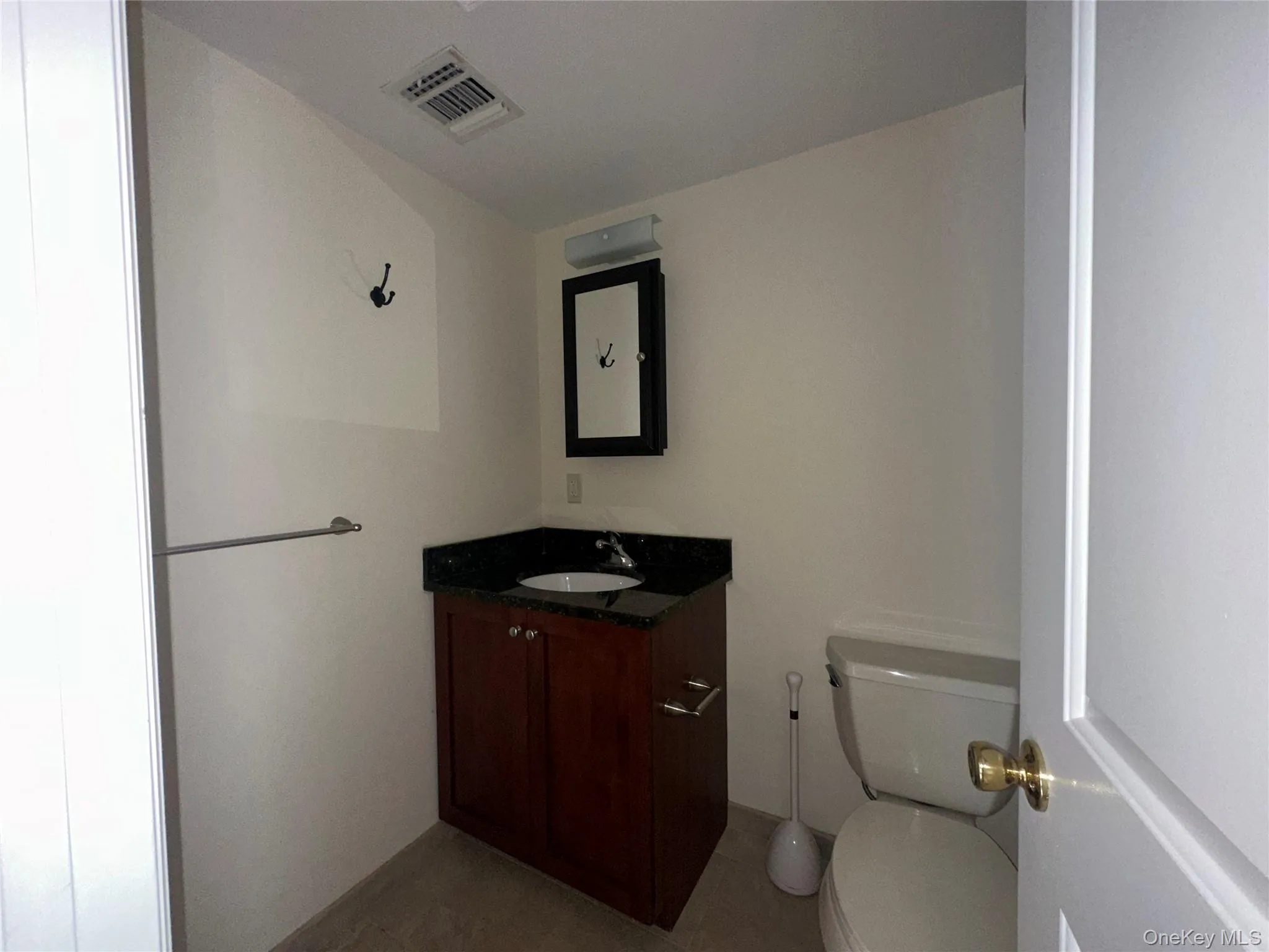 Half bath featuring vanity and toilet Half bath featuring vanity and toilet