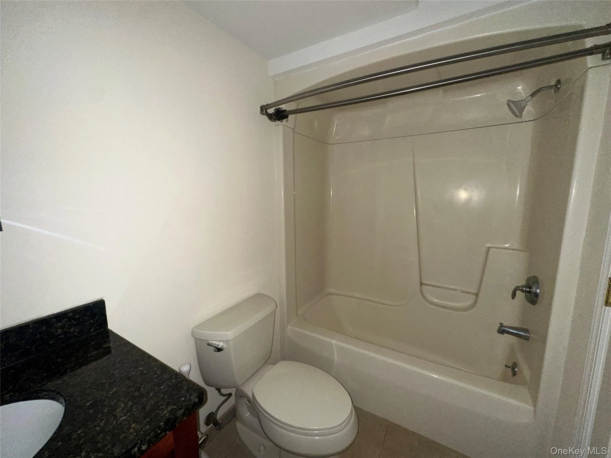 Bathroom featuring shower / tub combination, vanity, and tile patterned floors Bathroom featuring shower / tub combination, vanity, and tile patterned floors