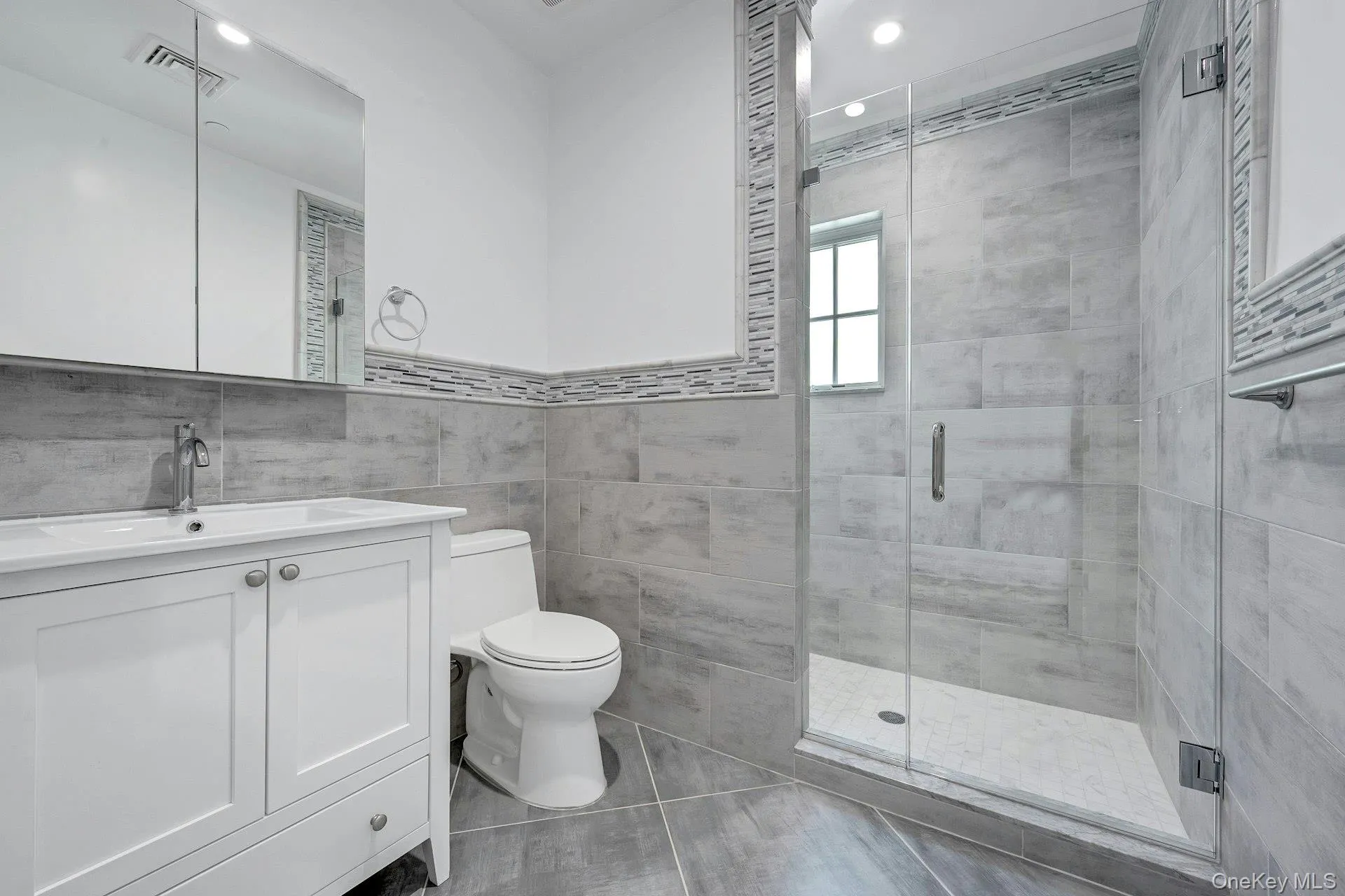 Bathroom with vanity, a stall shower, tile walls, and recessed lighting Bathroom with vanity, a stall shower, tile walls, and recessed lighting