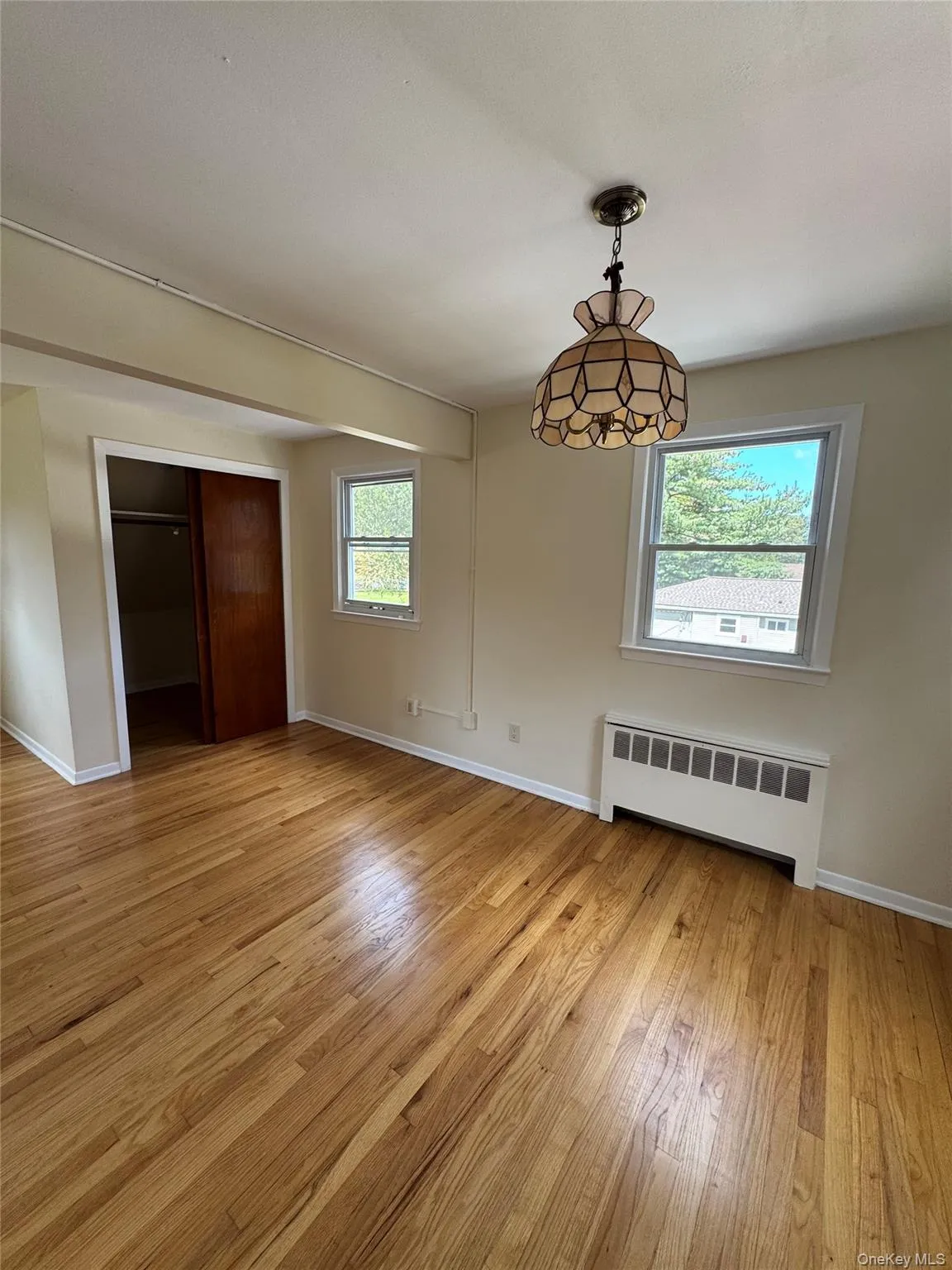 Unfurnished dining area with radiator heating unit and light wood finished floors Unfurnished dining area with radiator heating unit and light wood finished floors