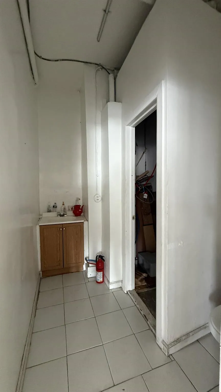 Hall featuring light tile patterned flooring and baseboards Hall featuring light tile patterned flooring and baseboards